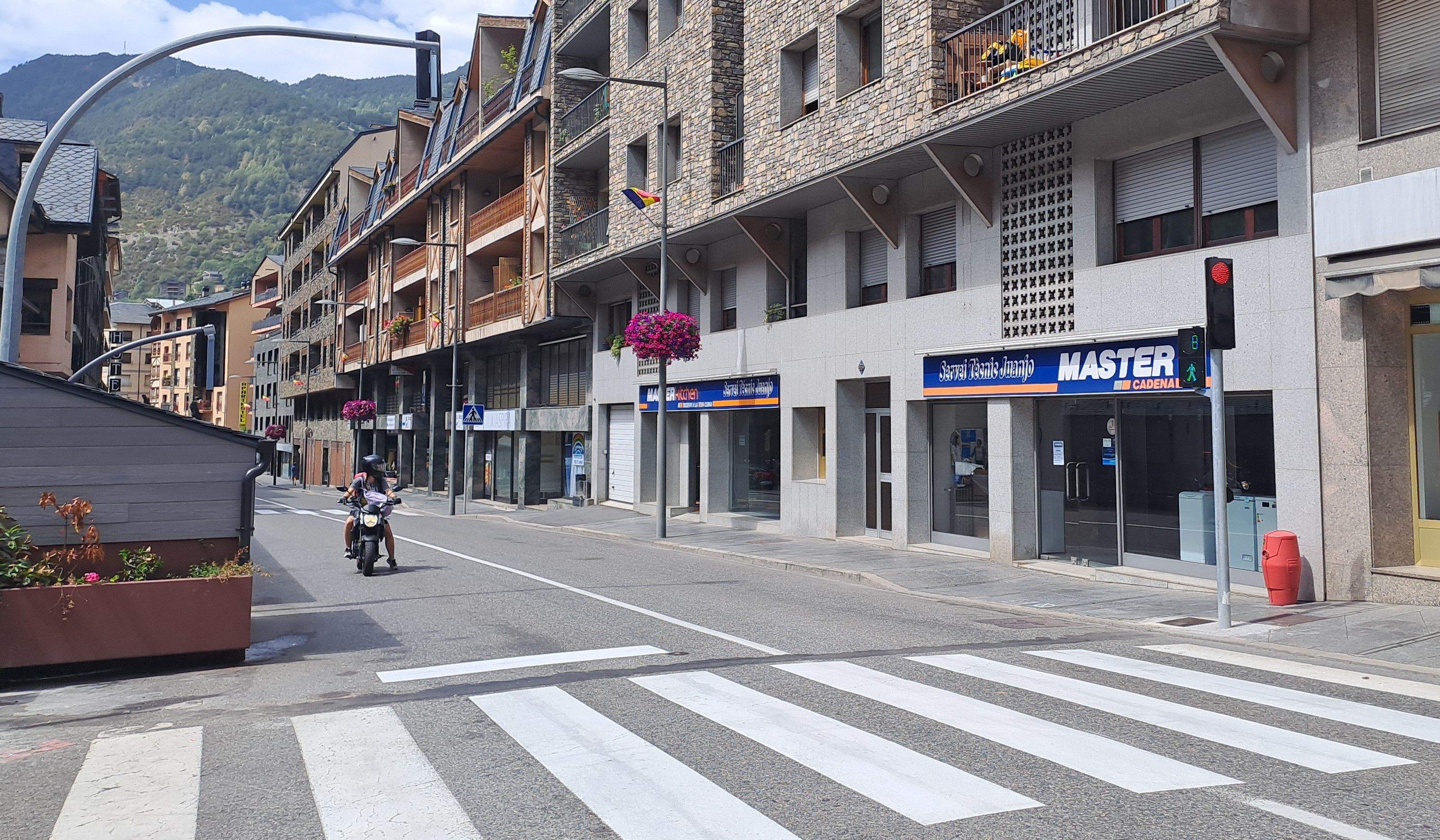 Una moto espera que el nou semàfor es posi verd.