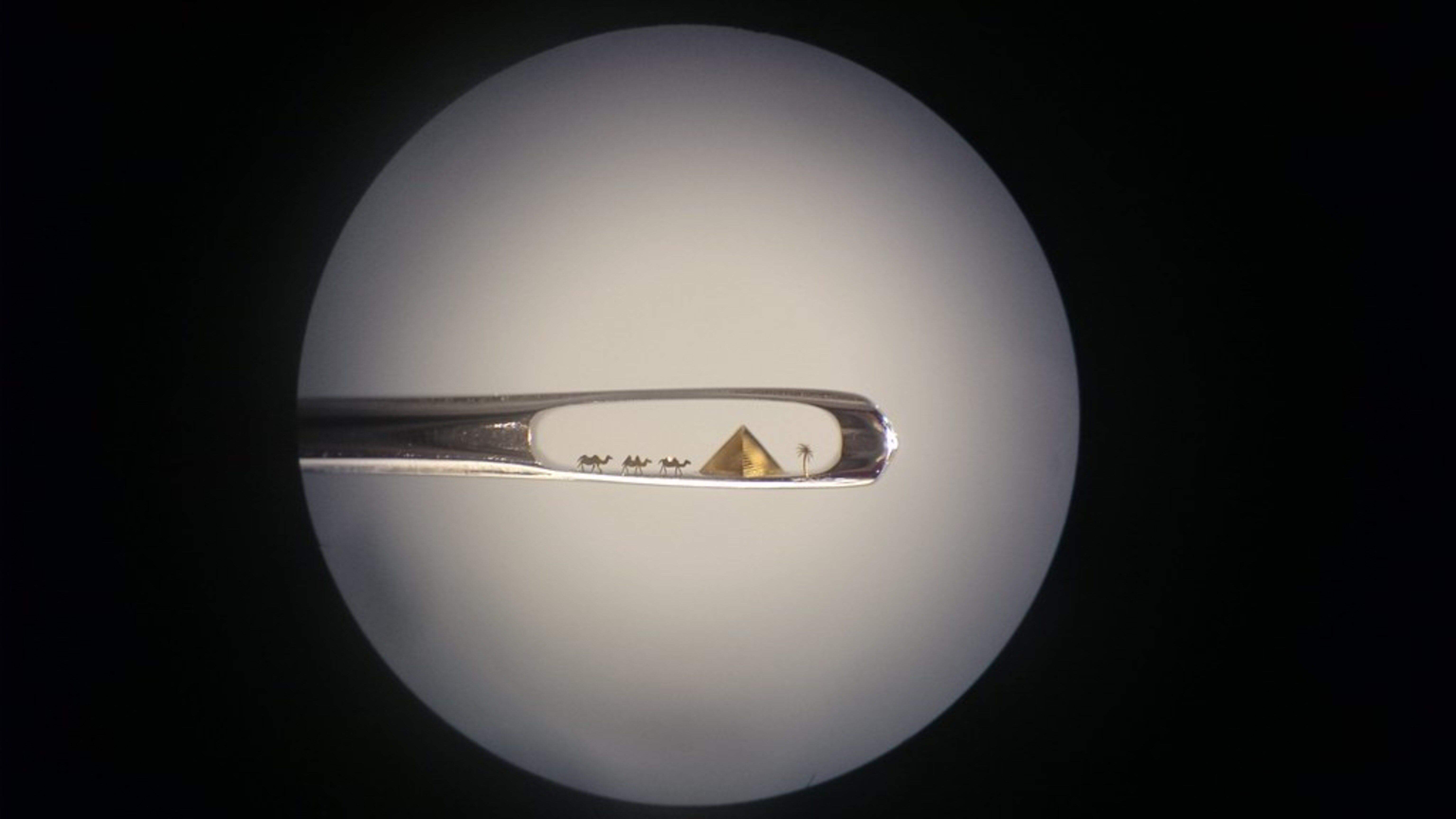 Uns dromedaris i una piràmide en una agulla de cap.