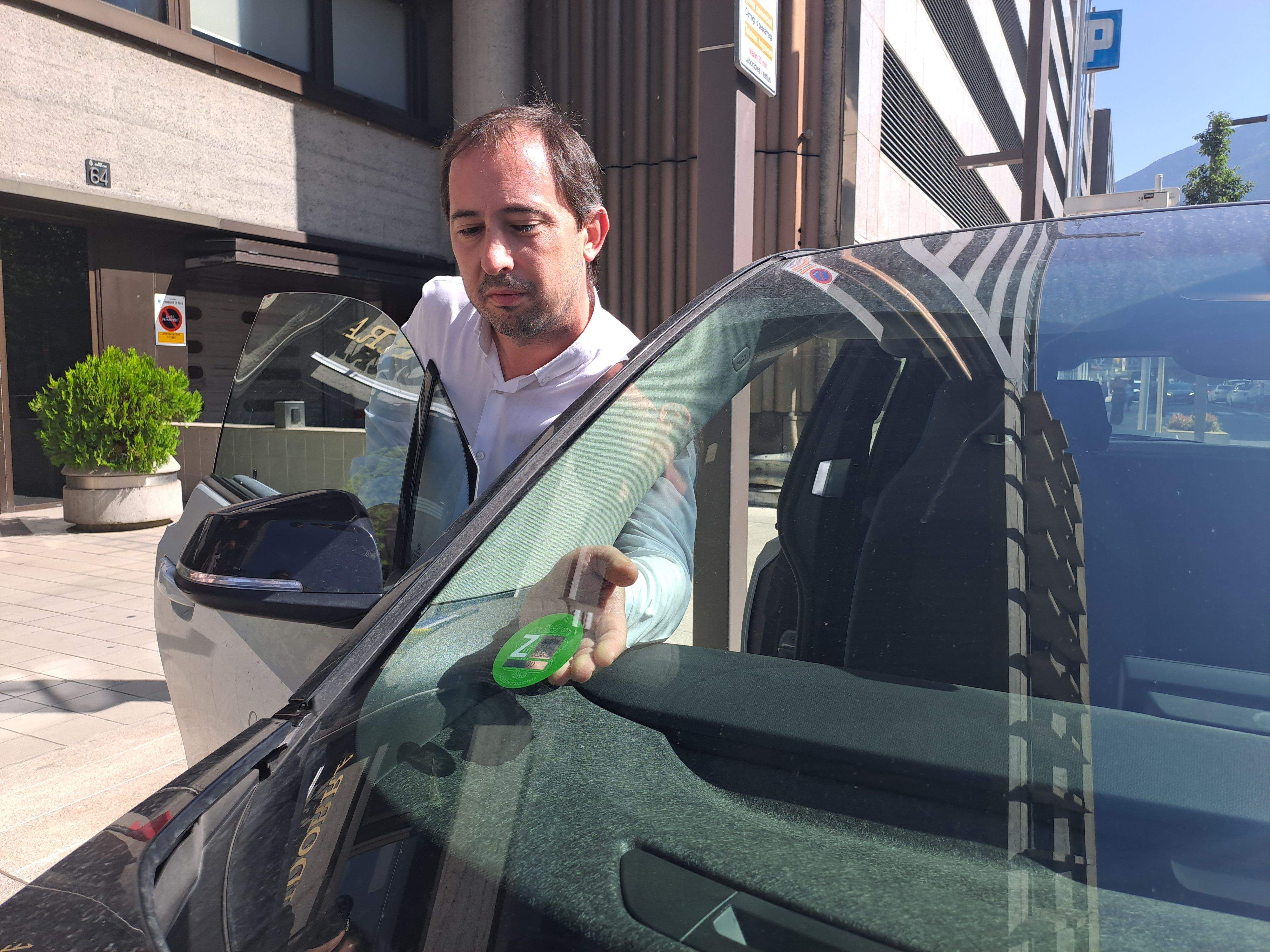 Carles Miquel, posant l'etiqueta a un dels vehicles de Govern.