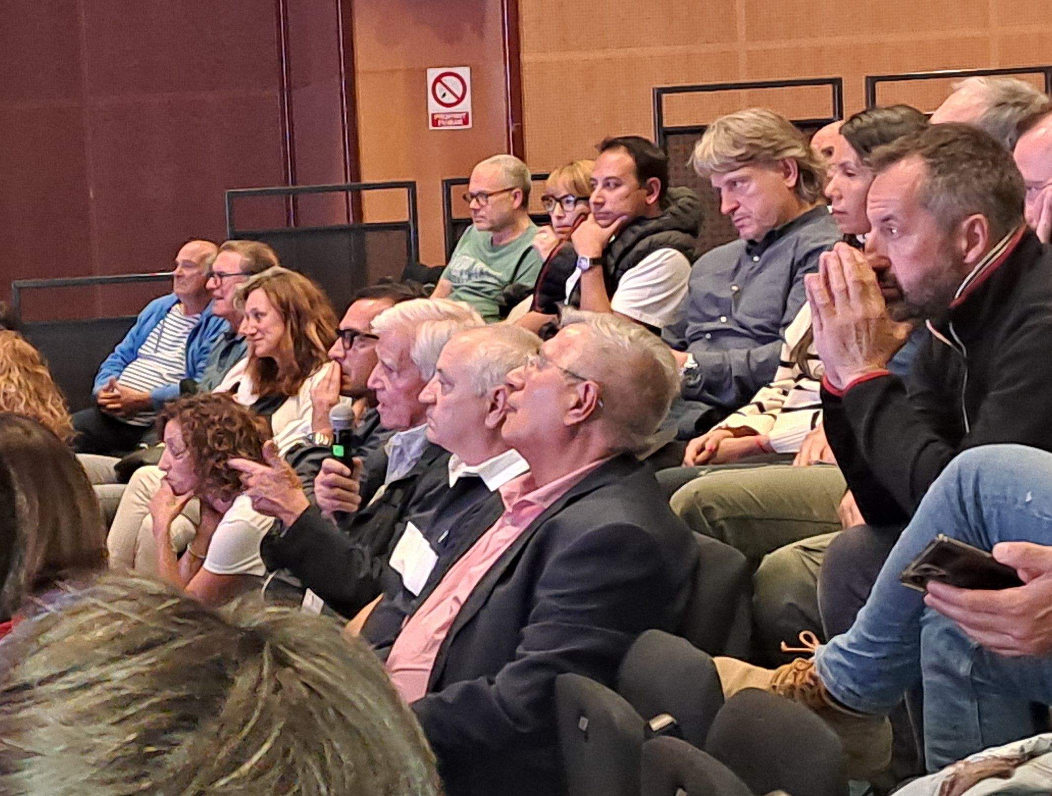 Alís, amb el micròfon, intervenint durant la reunió de poble.