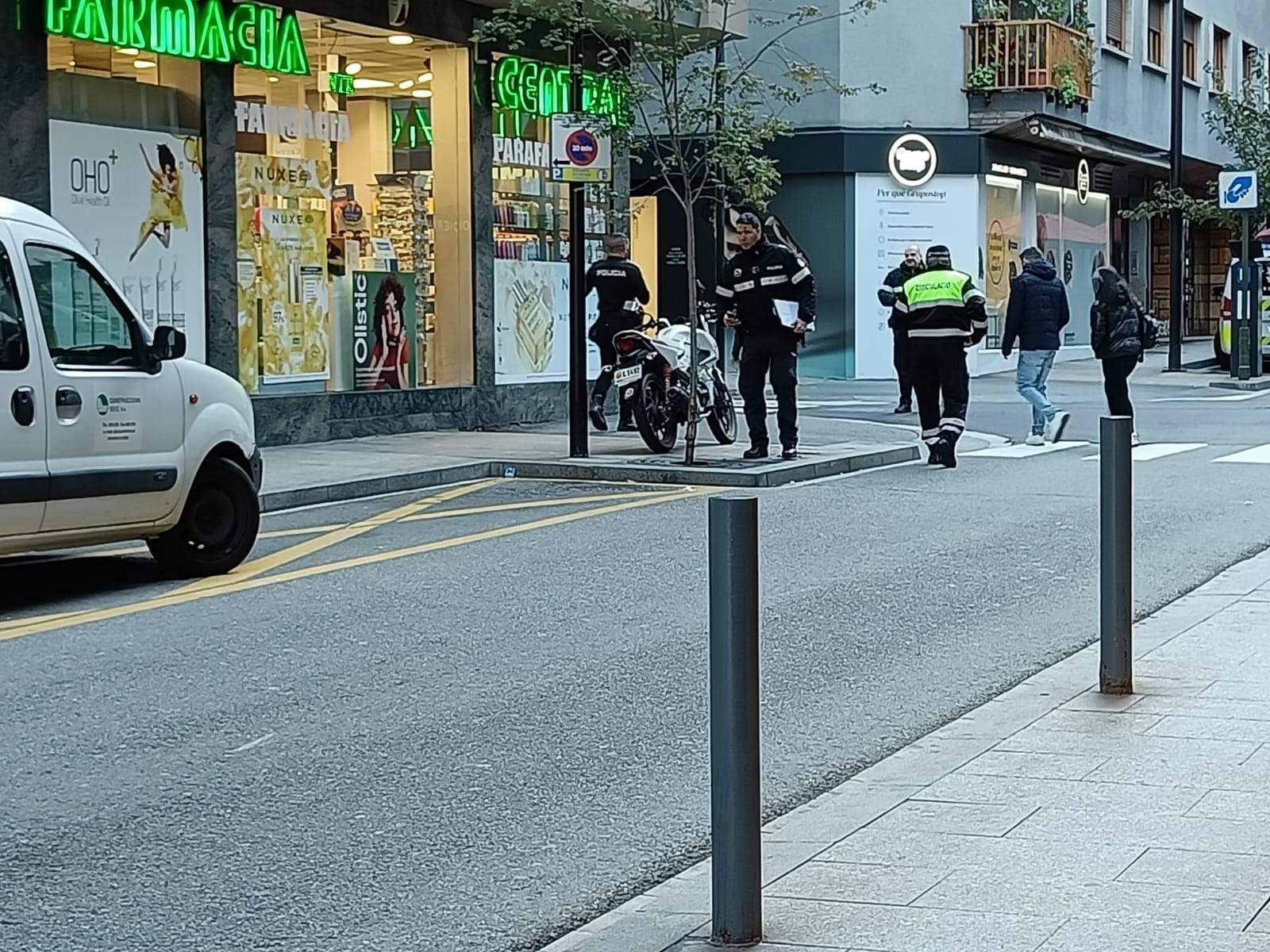 Agents de policia i de circulació al lloc del fet observant la moto implicada.