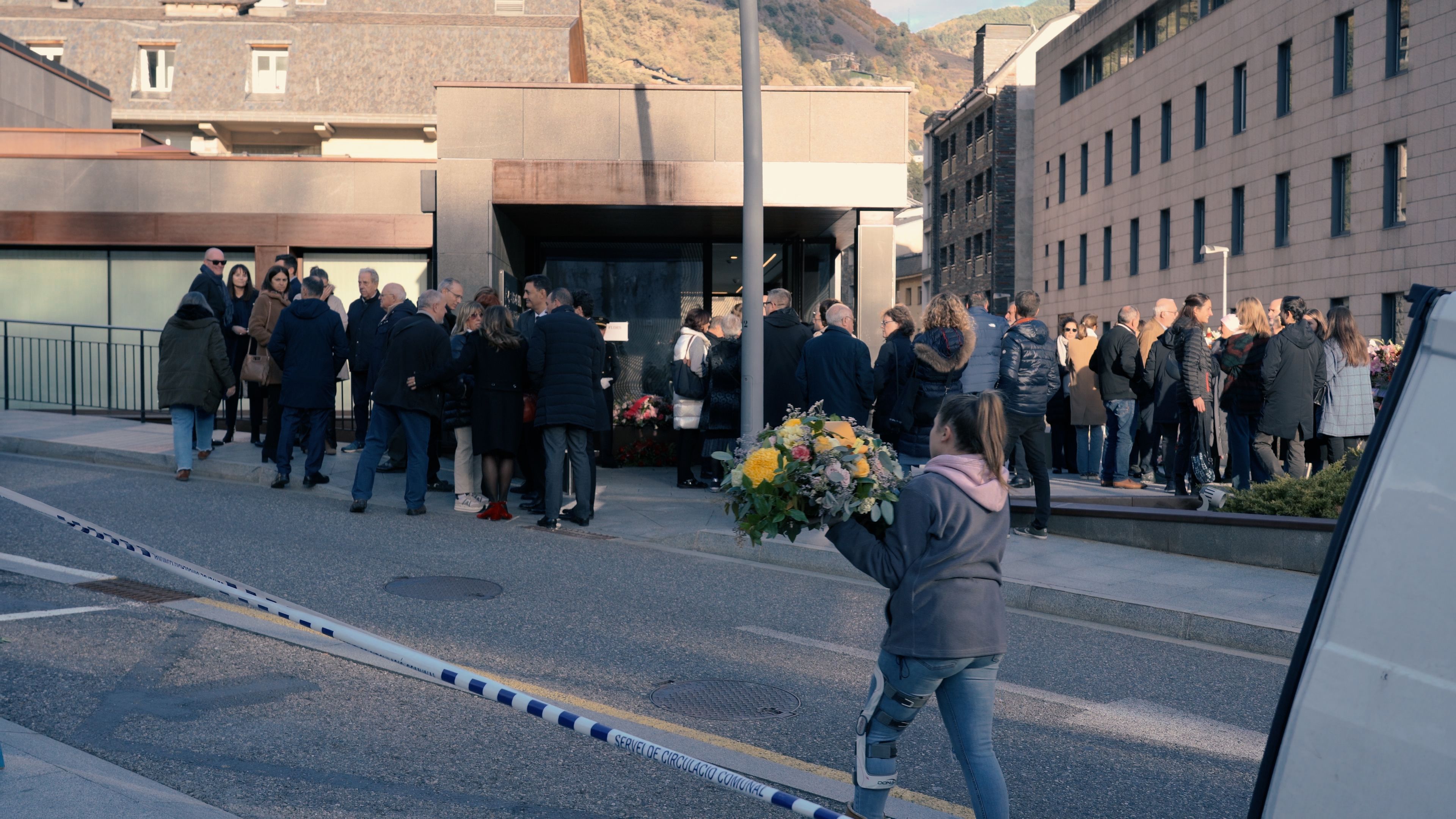 Una corona de flors arriba al tanatori, ja amb moltes cues de gent, autoritats incloses, a l'exterior.