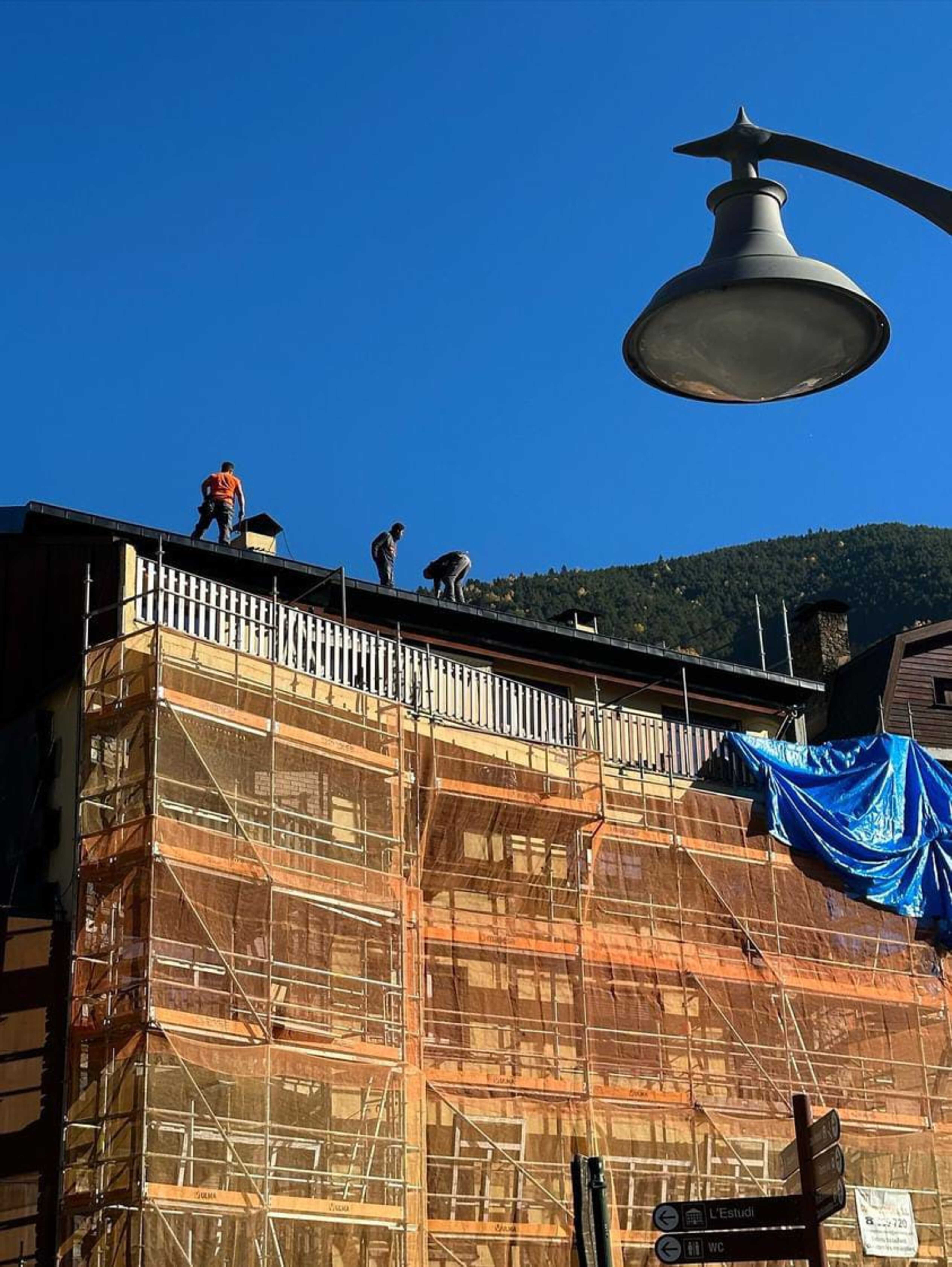 Els tres obrers al capdamunt de l'edifici.