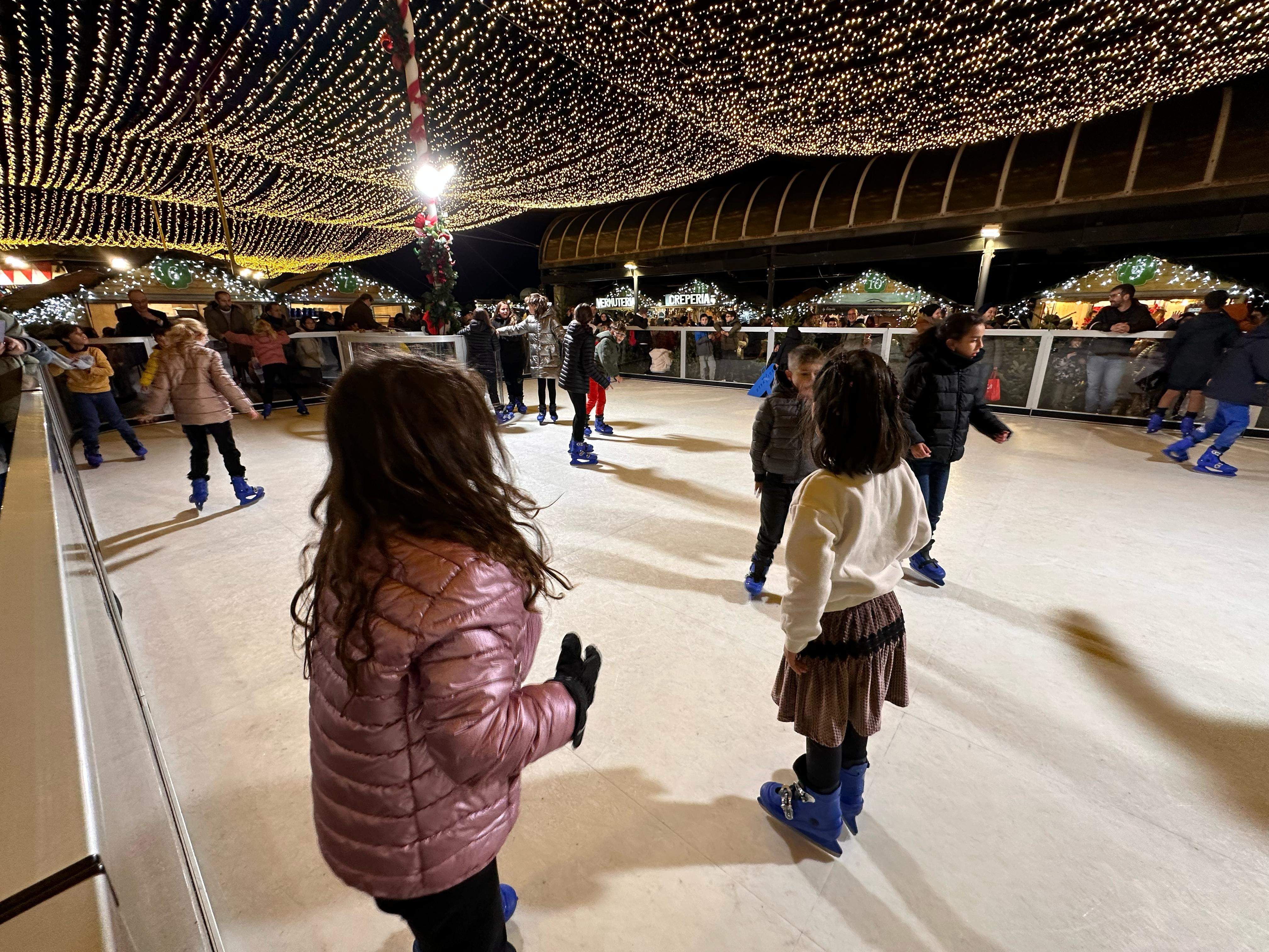Els infants gaudeixen amb la pista de gel sintètic.