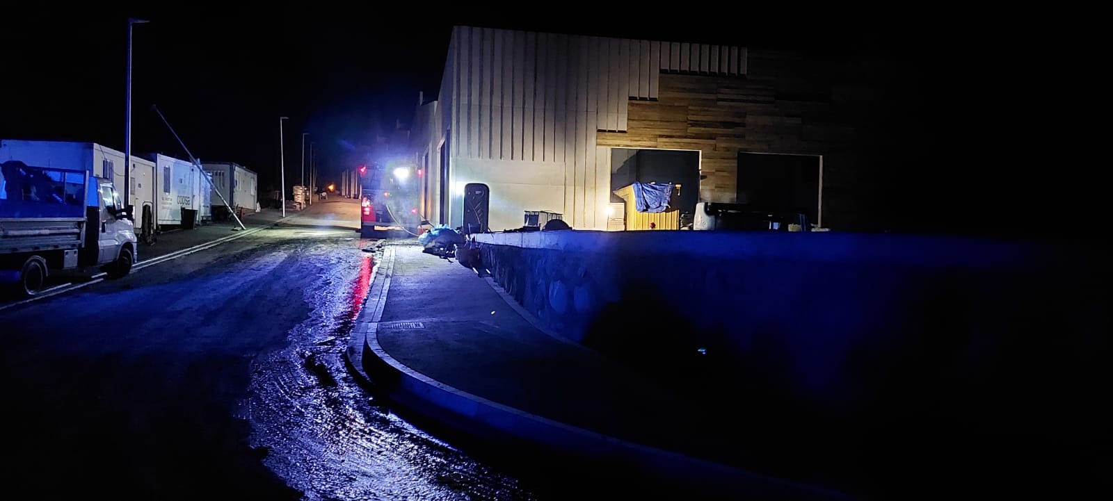 Un camió de bombers al costat de la nau on hi ha hagut, en el seu exterior, l'incident amb el foc.