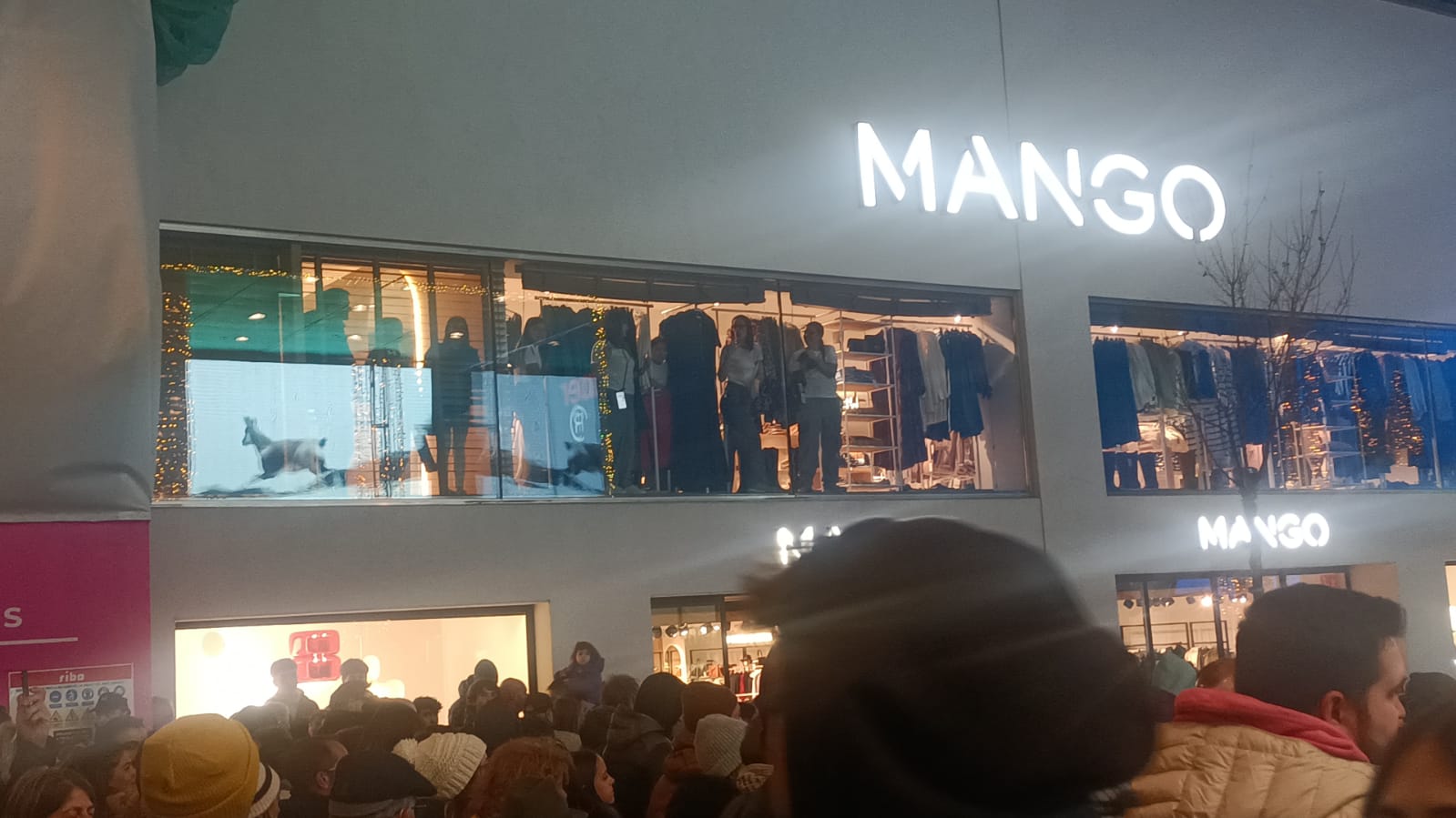 Treballadores d'un establiment aplaudint el pas de la manifestació.