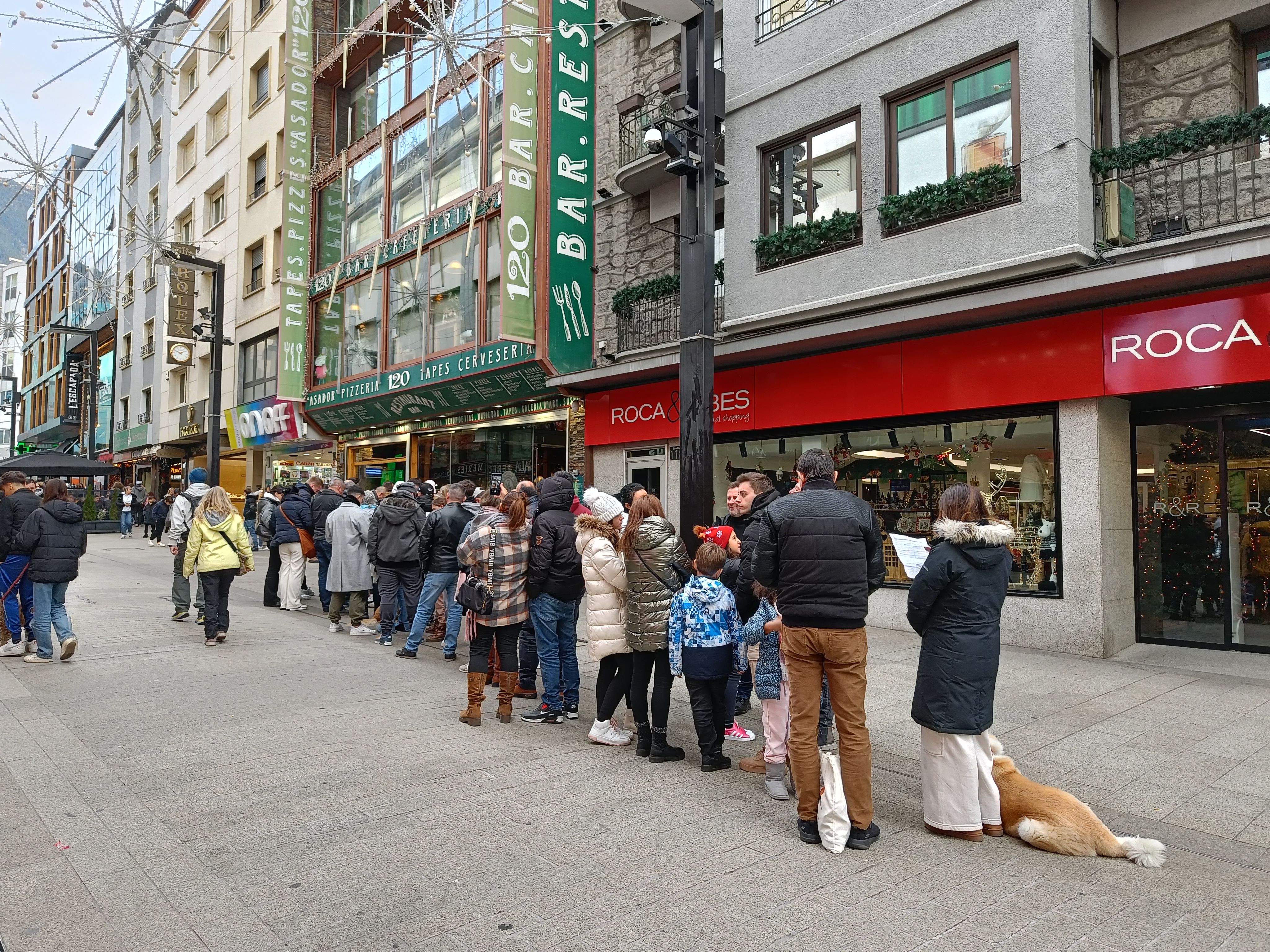 Turistes fent cua per entrar en un restaurant a l'avinguda Meritxell.