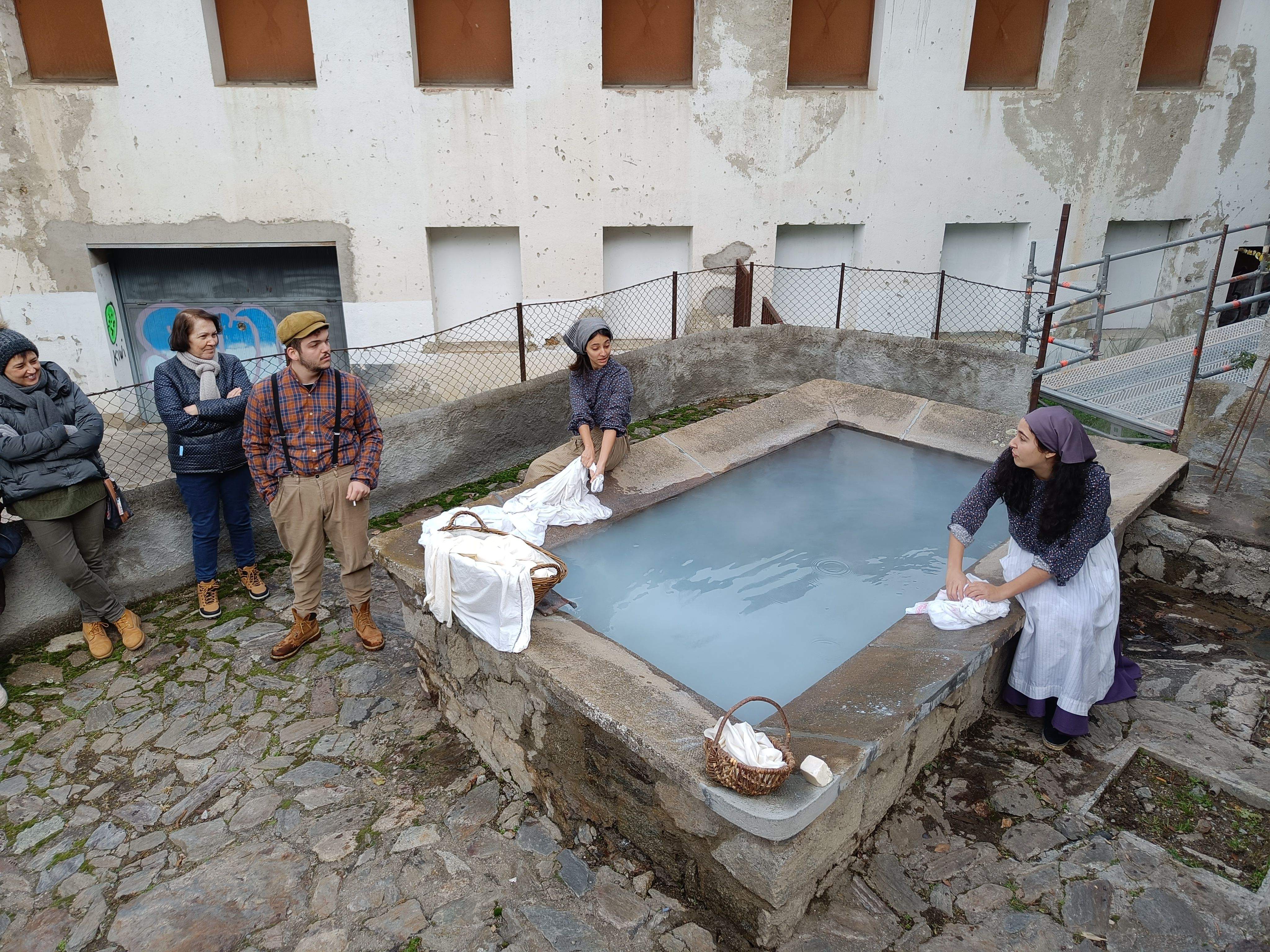 Un treballador de la fàbrica de la llana conversa amb dues noies al safareig del Barri.