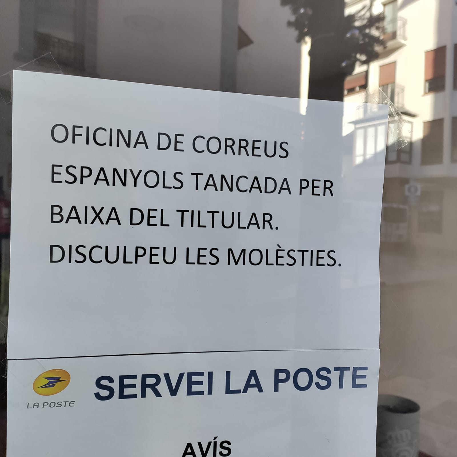 Cartell a la porta de l'oficina.