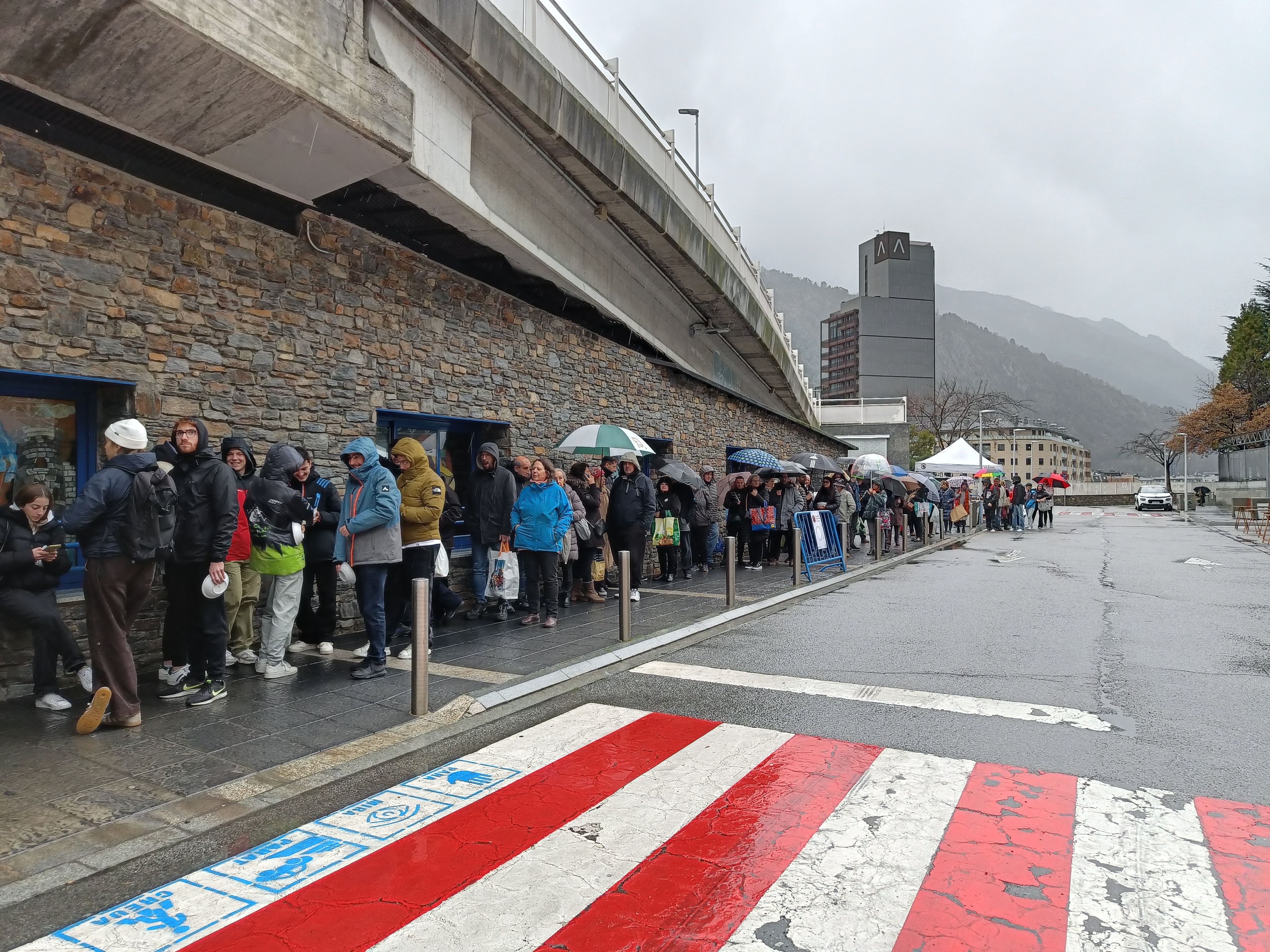 Amb o sense paraigües, la gent ha fet cua per l'escudella a Escaldes. Amb o sense paraigües, la gent ha fet cua per l'escudella a Escaldes.