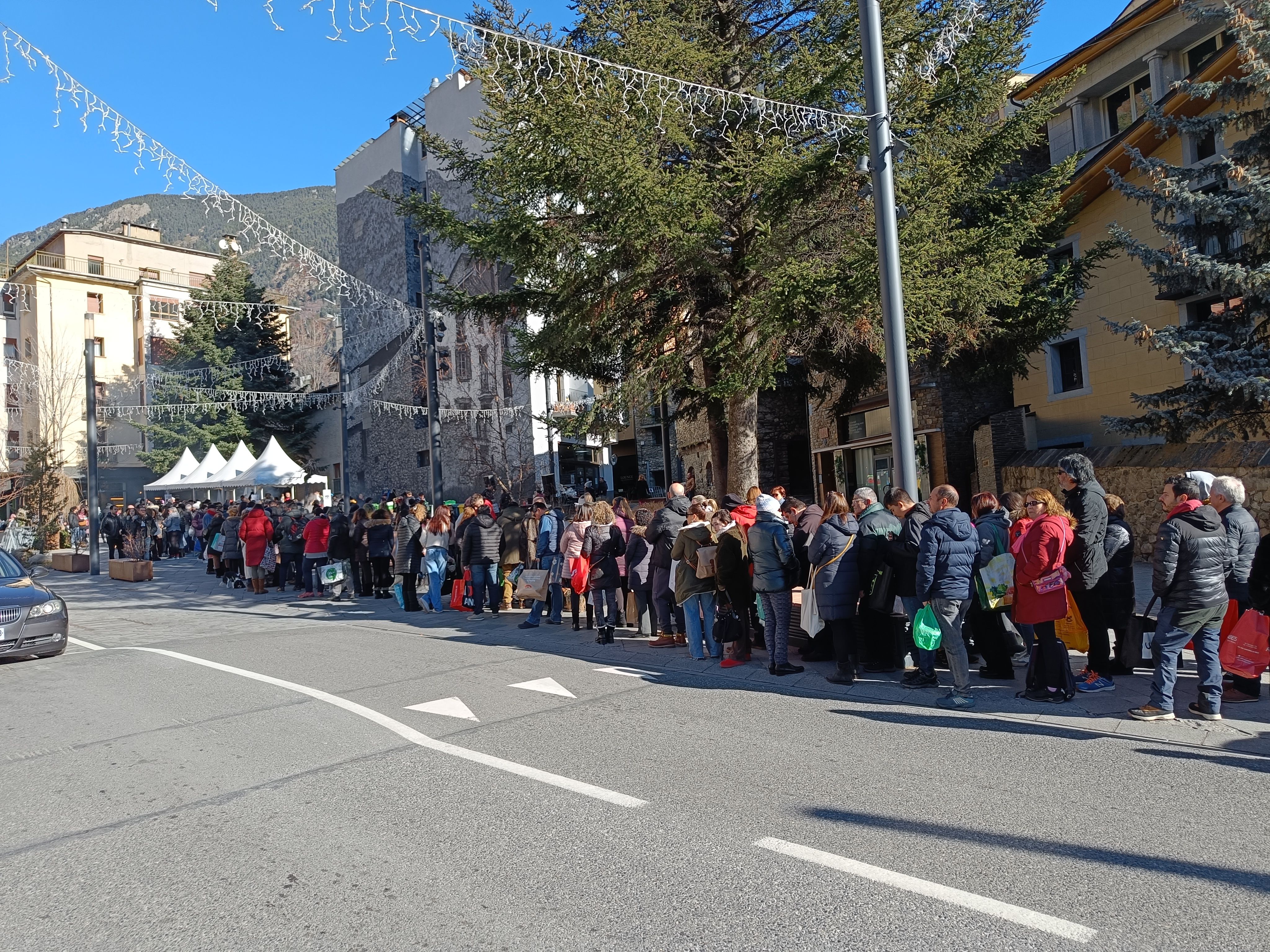 Cua immensa per recollir l'escudella.