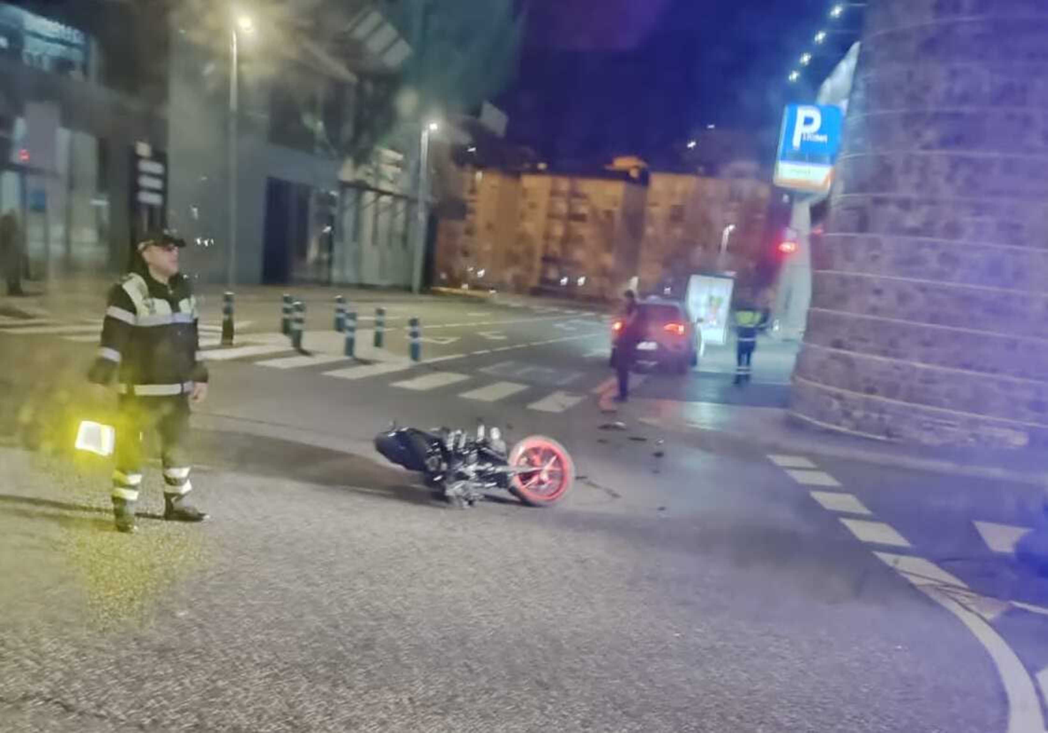 La moto per terra i un agent de circulació vetllant per la situació.