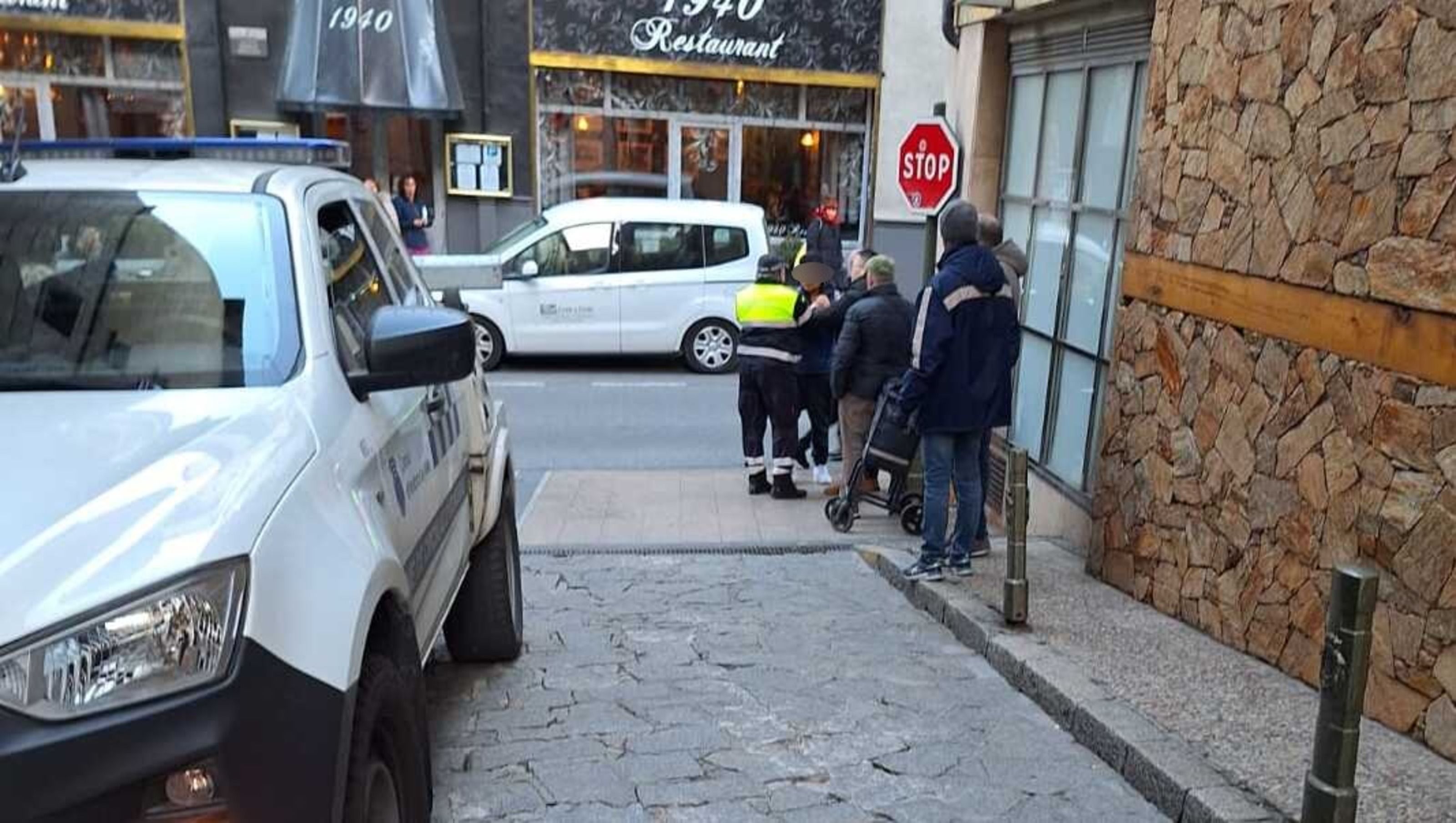 Un agent de circulació parlant amb el menor en presència del botiguer.