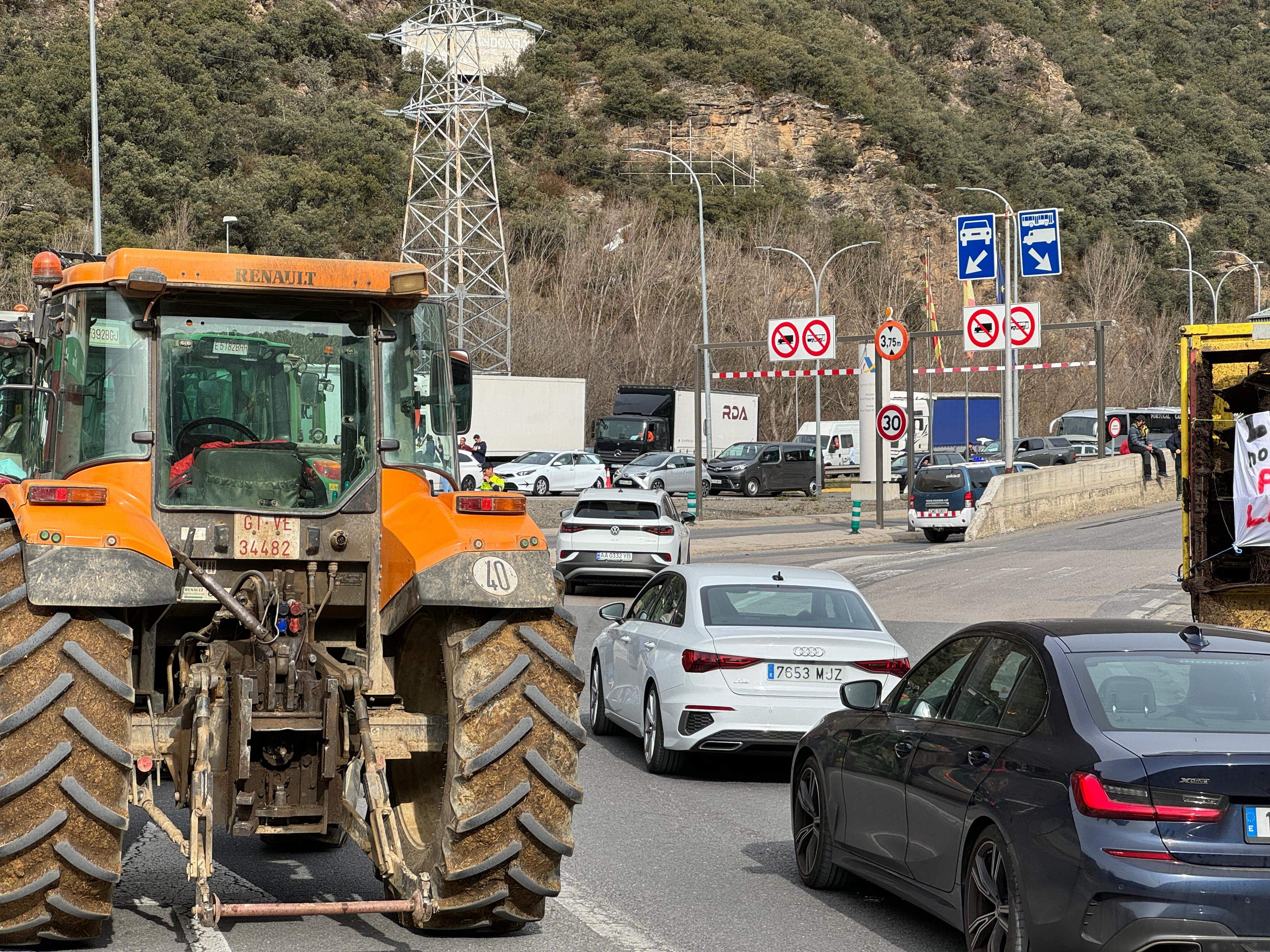Vehicles atansant-se a la Farga de Moles entre tractors i remolcs.