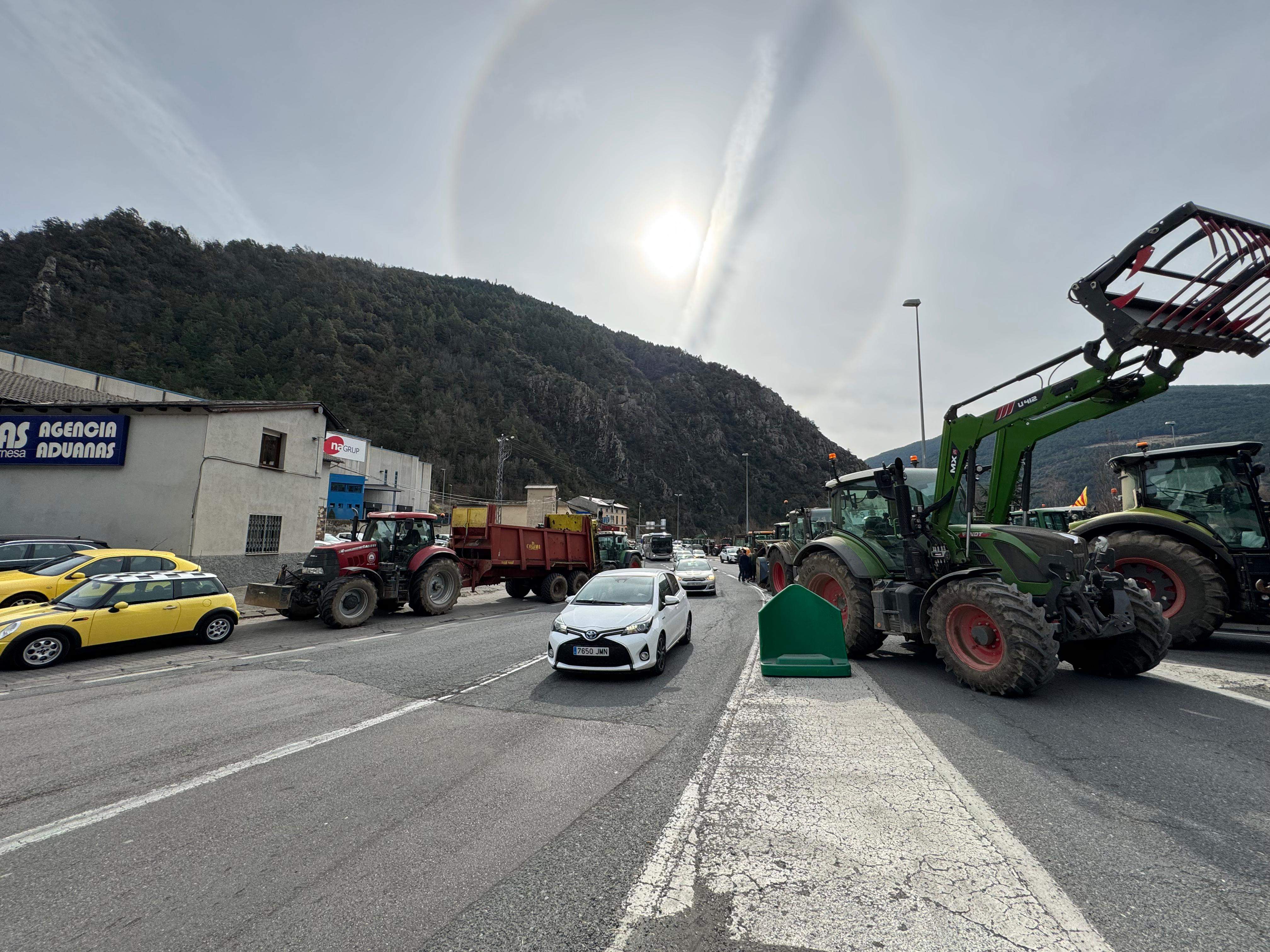 Vehicles atansant-se a la Farga de Moles entre tractors i remolcs.
