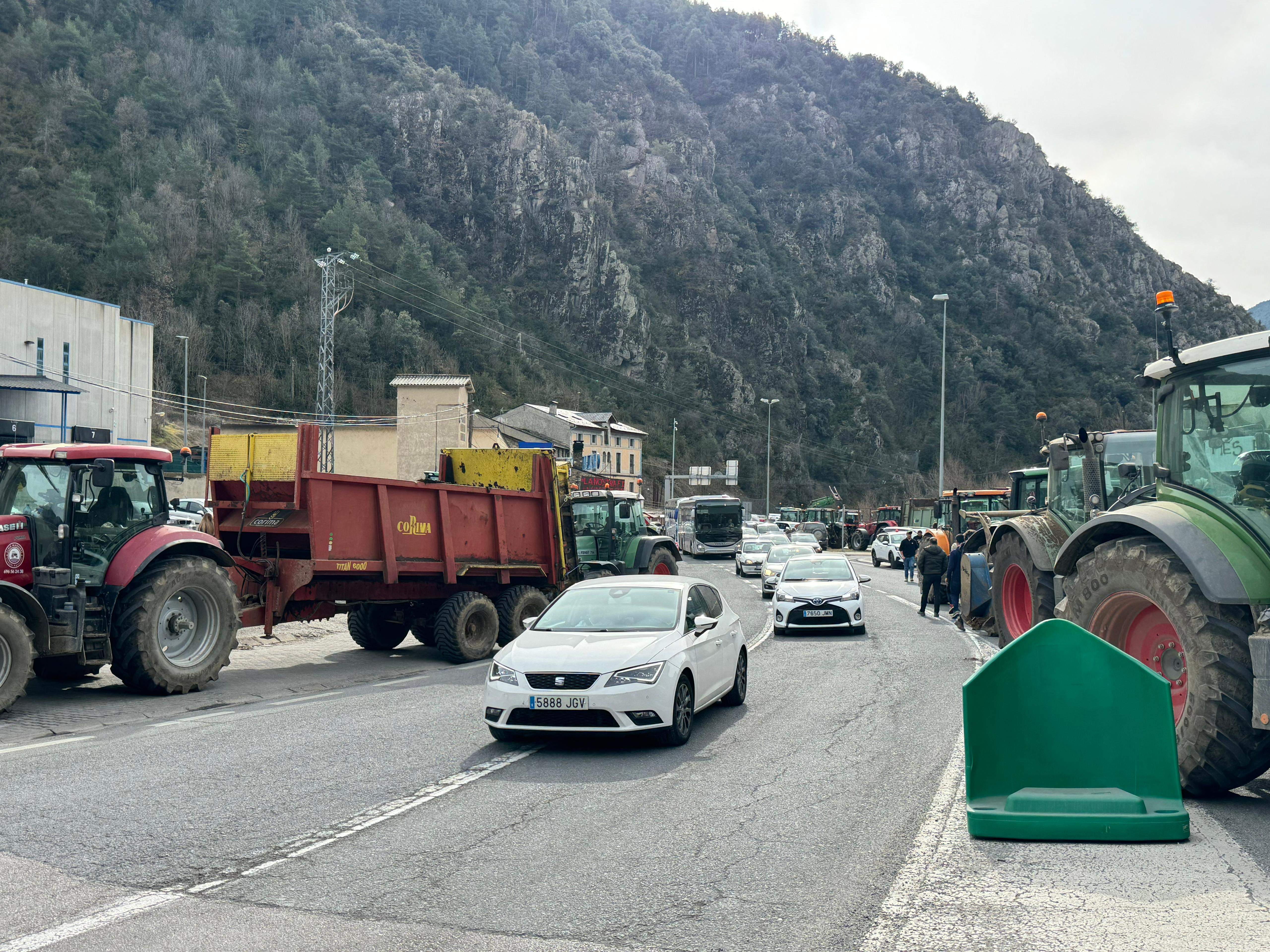 Vehicles atansant-se a la Farga de Moles entre tractors i remolcs.