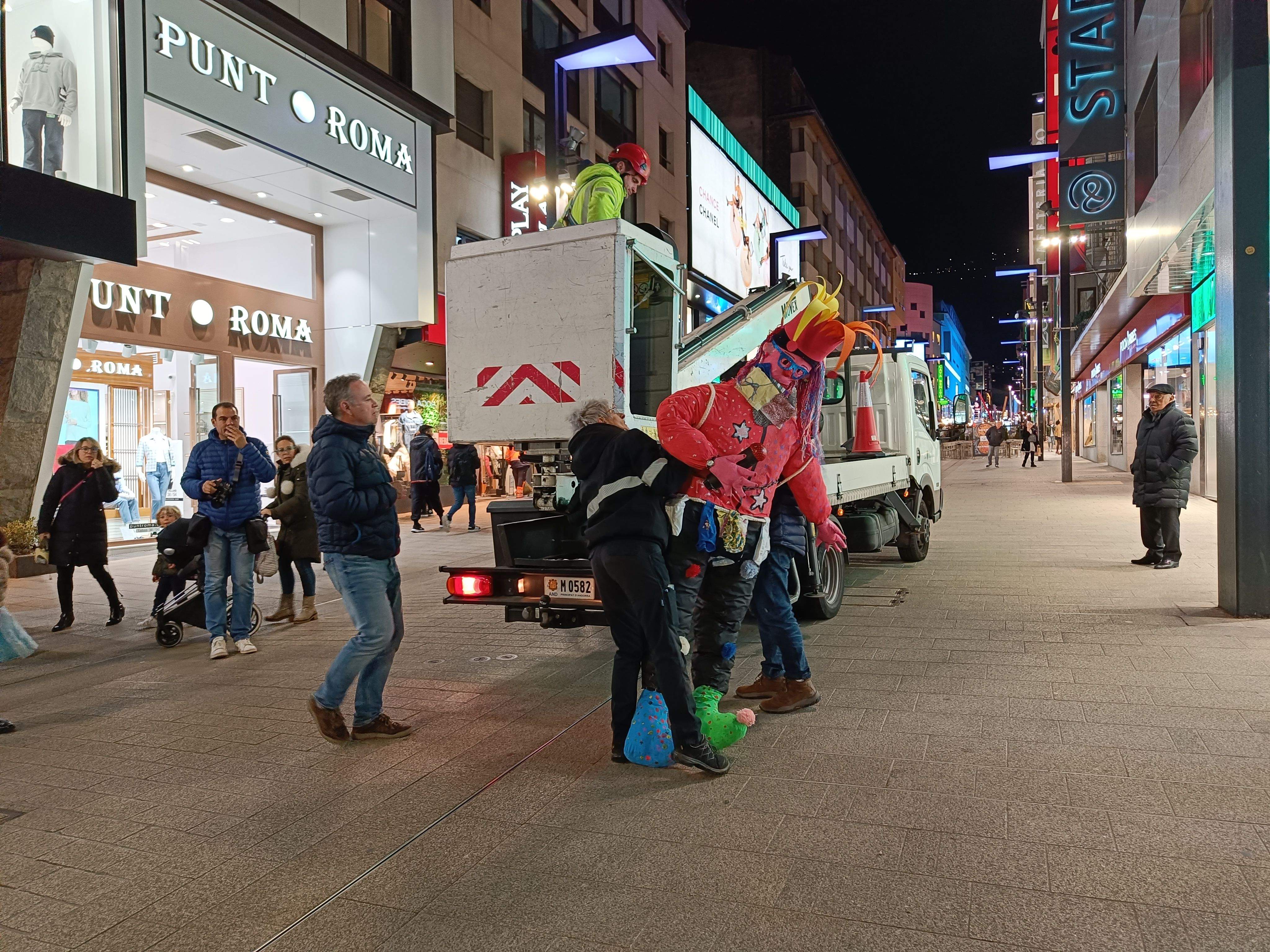 Operaris comunals col·locant el Carnestoltes a la grua.