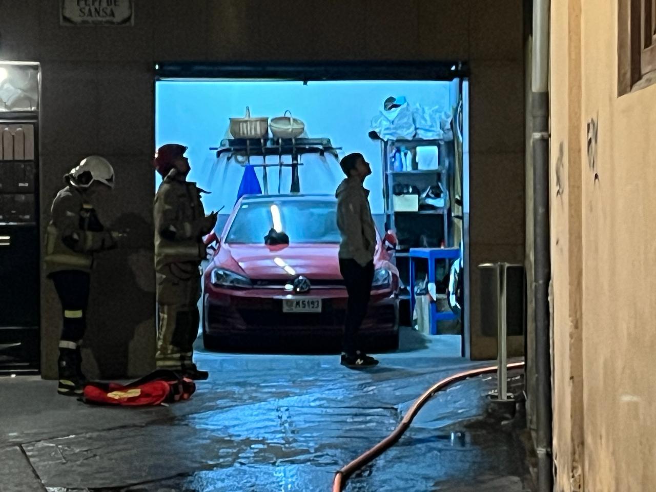 Bombers i veïns observant el lloc de l'incendi.