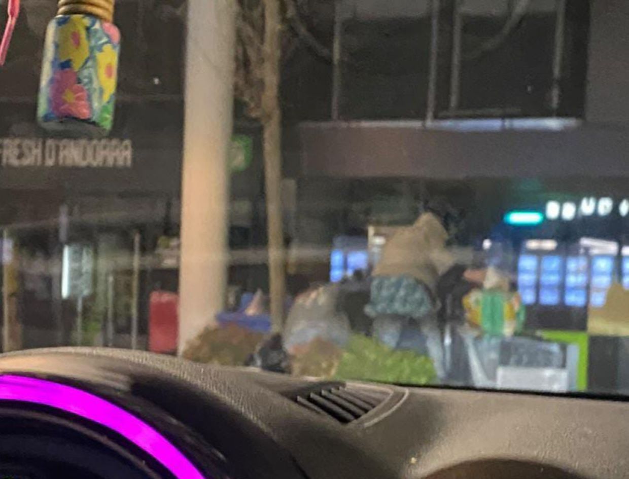 Una dona furgant en els contenidors el passat diumenge al carrer Prat de la Creu.