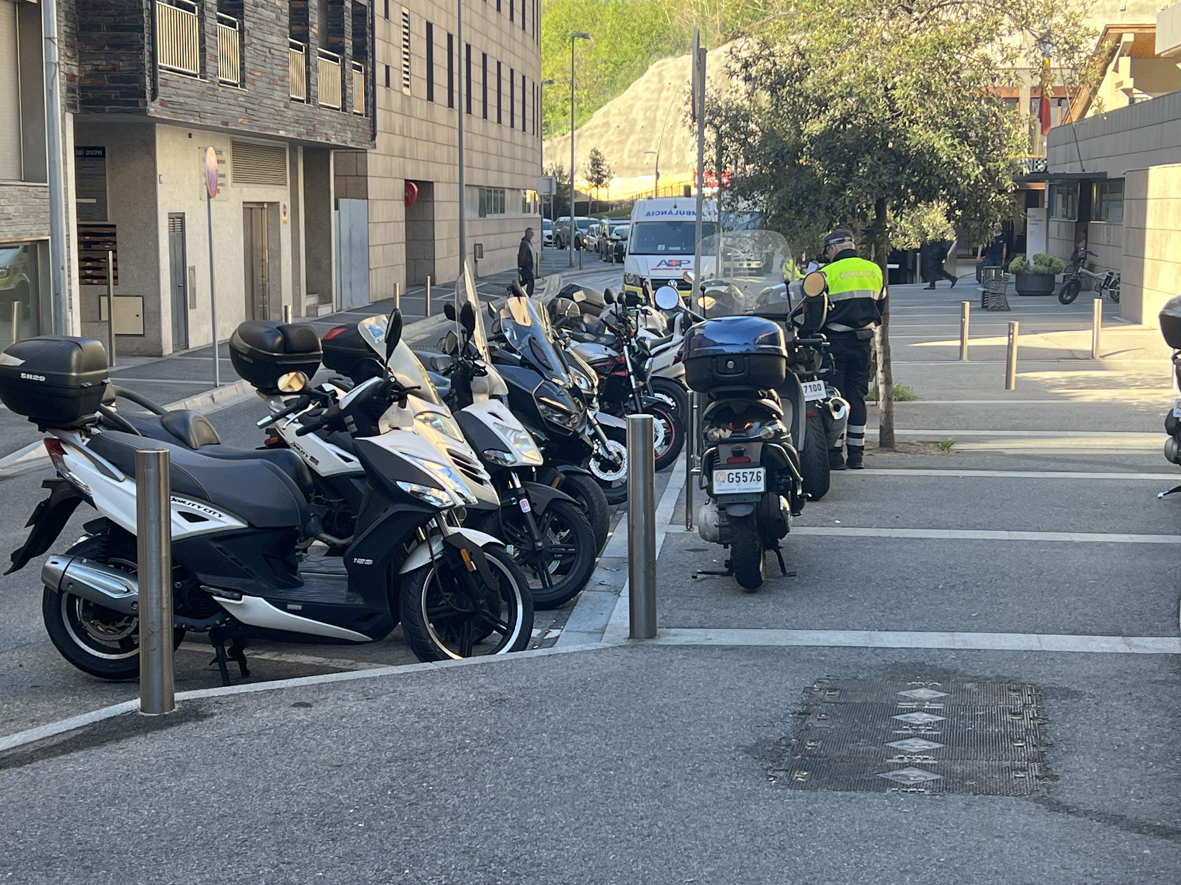 Un agent de circulació imposant multes a les motos aparcades damunt la vorera.