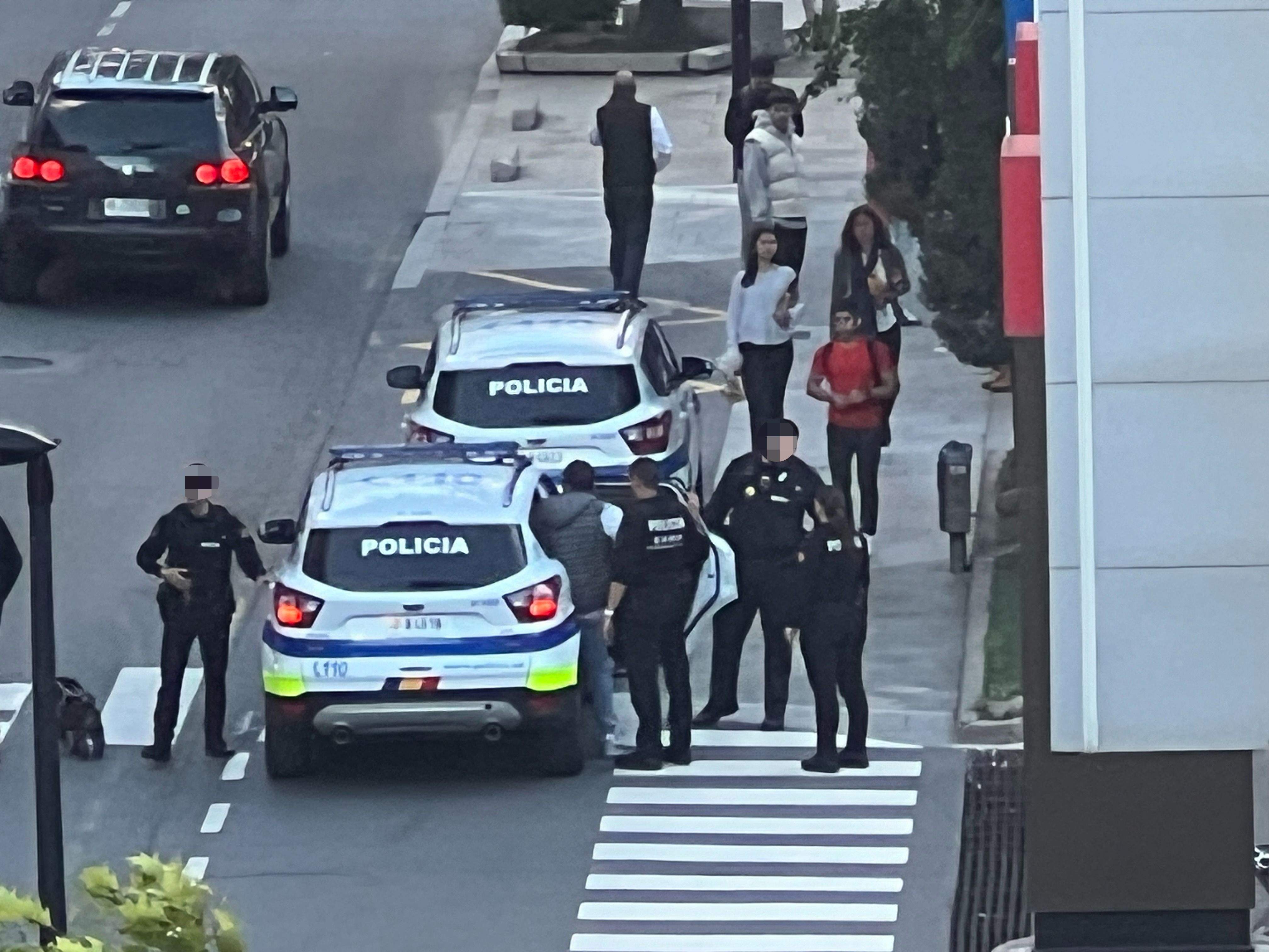 Els agents fent pujar de mutu acord l'home a l'interior del cotxe policial.