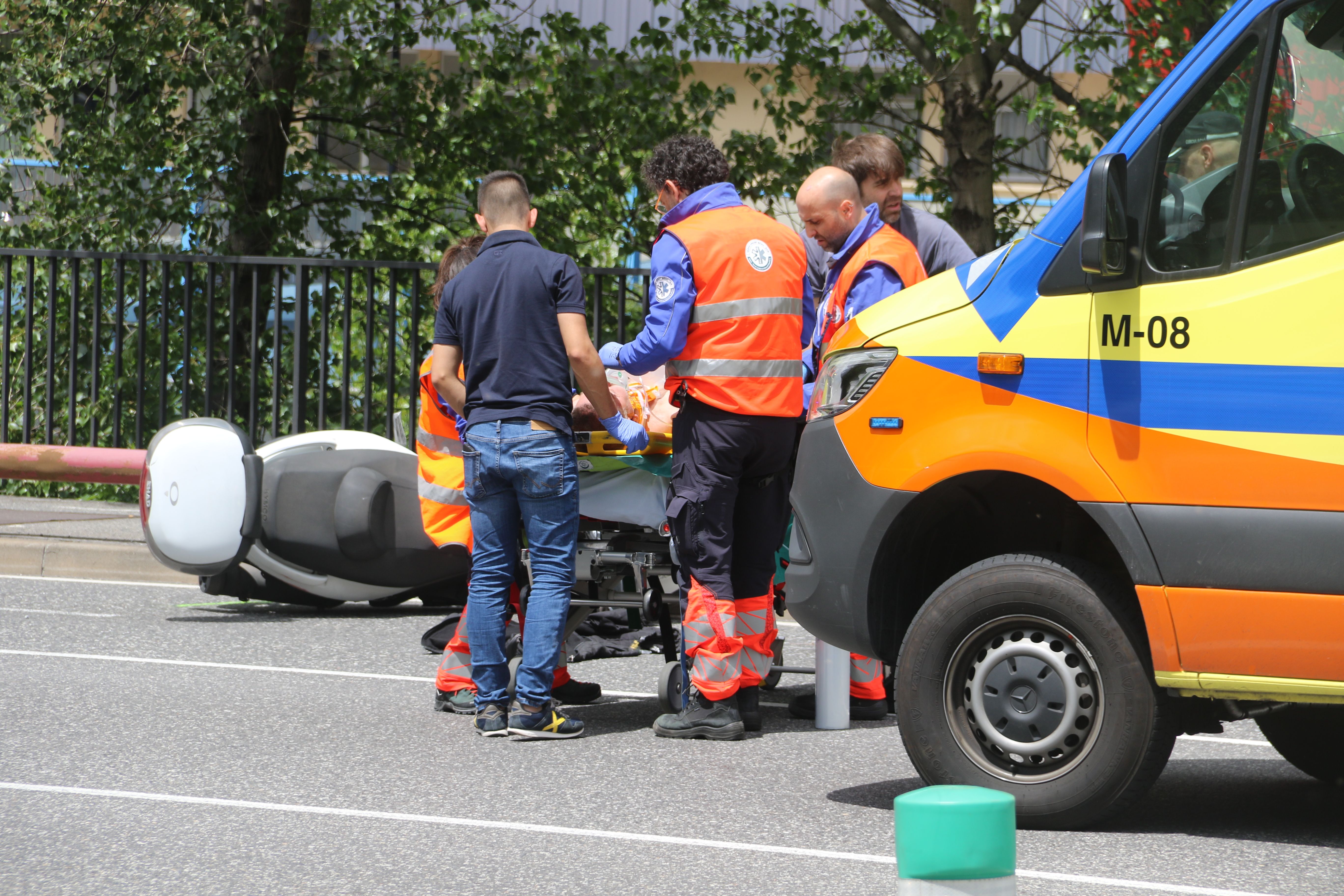 Els sanitaris atenent un dels ferits amb la moto en que viatjava al darrere.