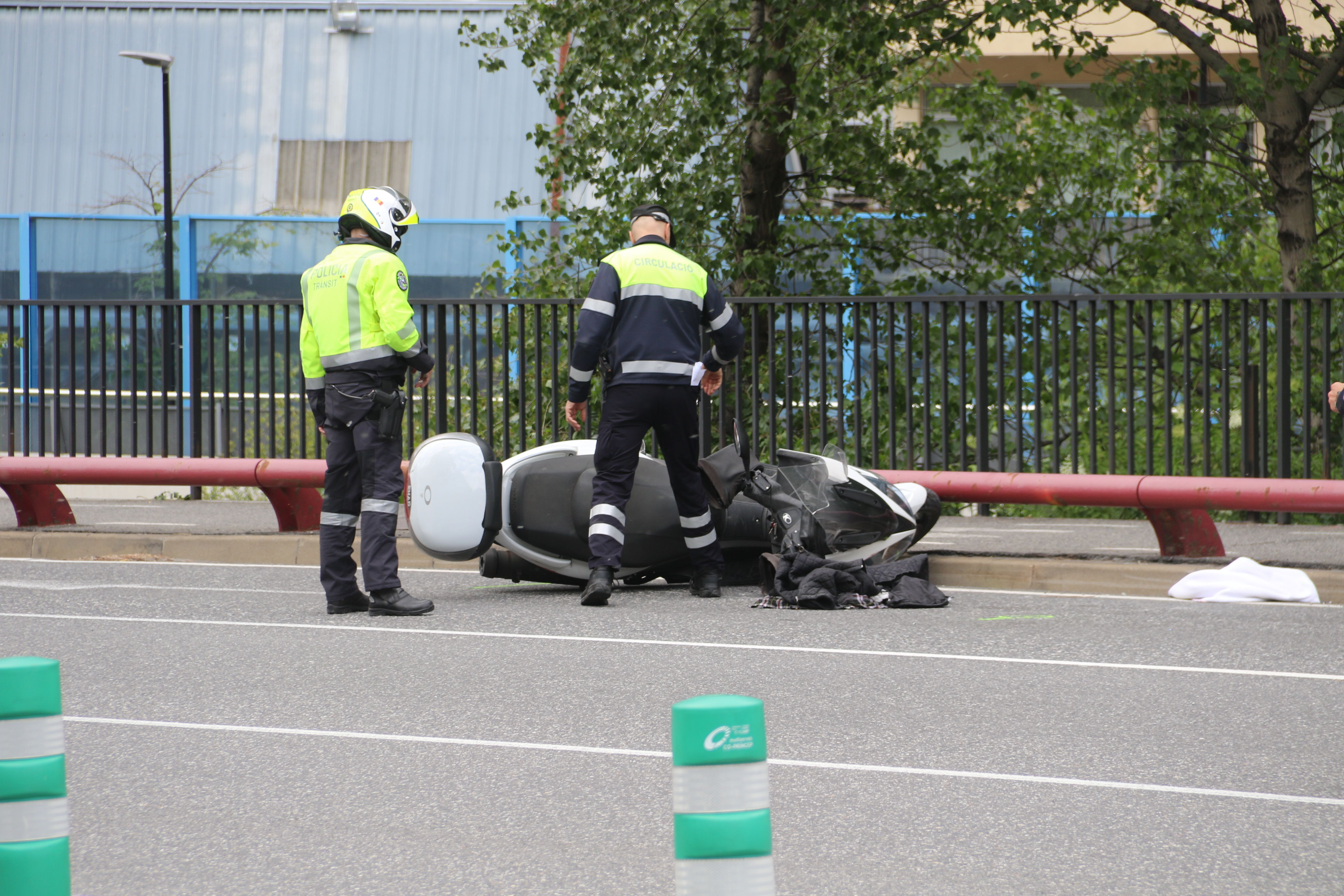 Un policia i un agent de circulació observant la moto implicada. Un policia i un agent de circulació observant la moto implicada.