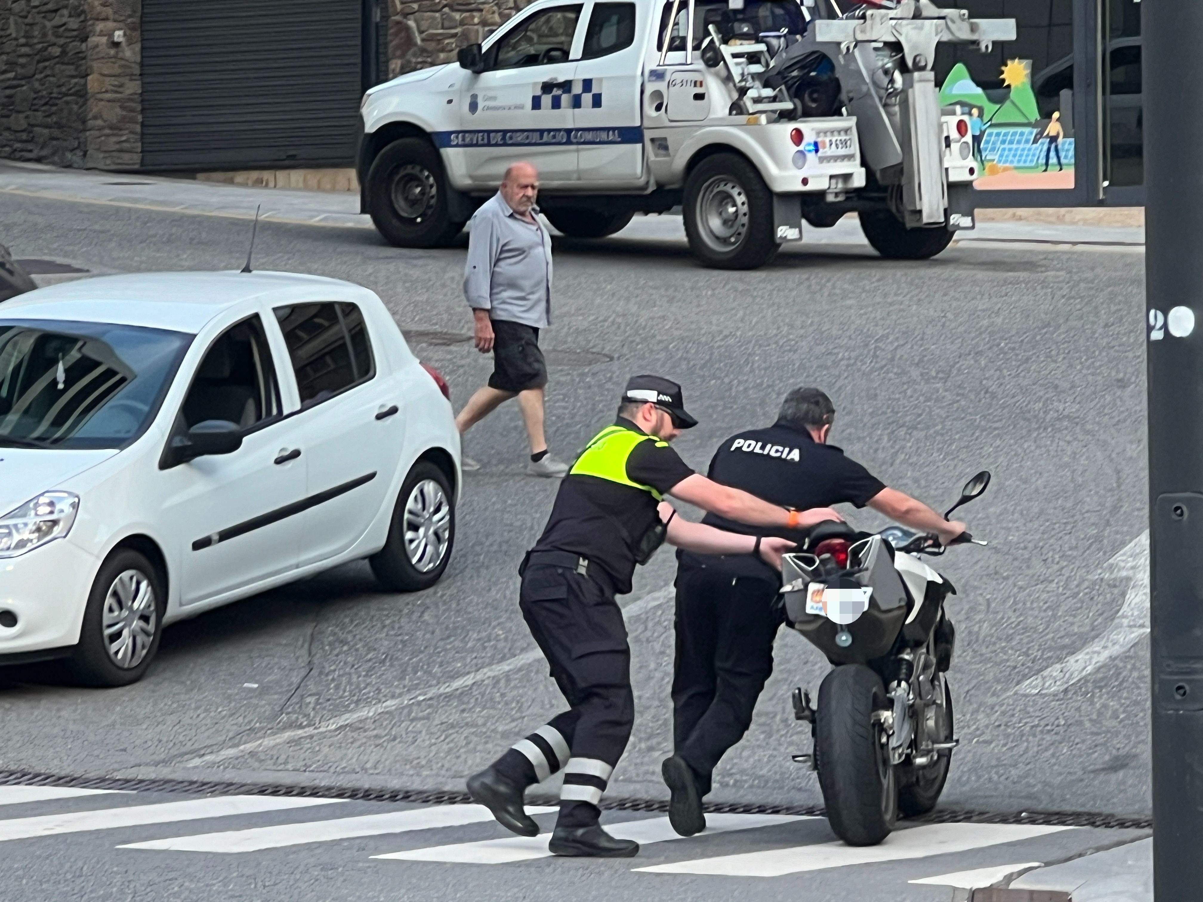 Un policia i un agent de circulació retiren la moto implicada en l'accident. Un policia i un agent de circulació retiren la moto implicada en l'accident.