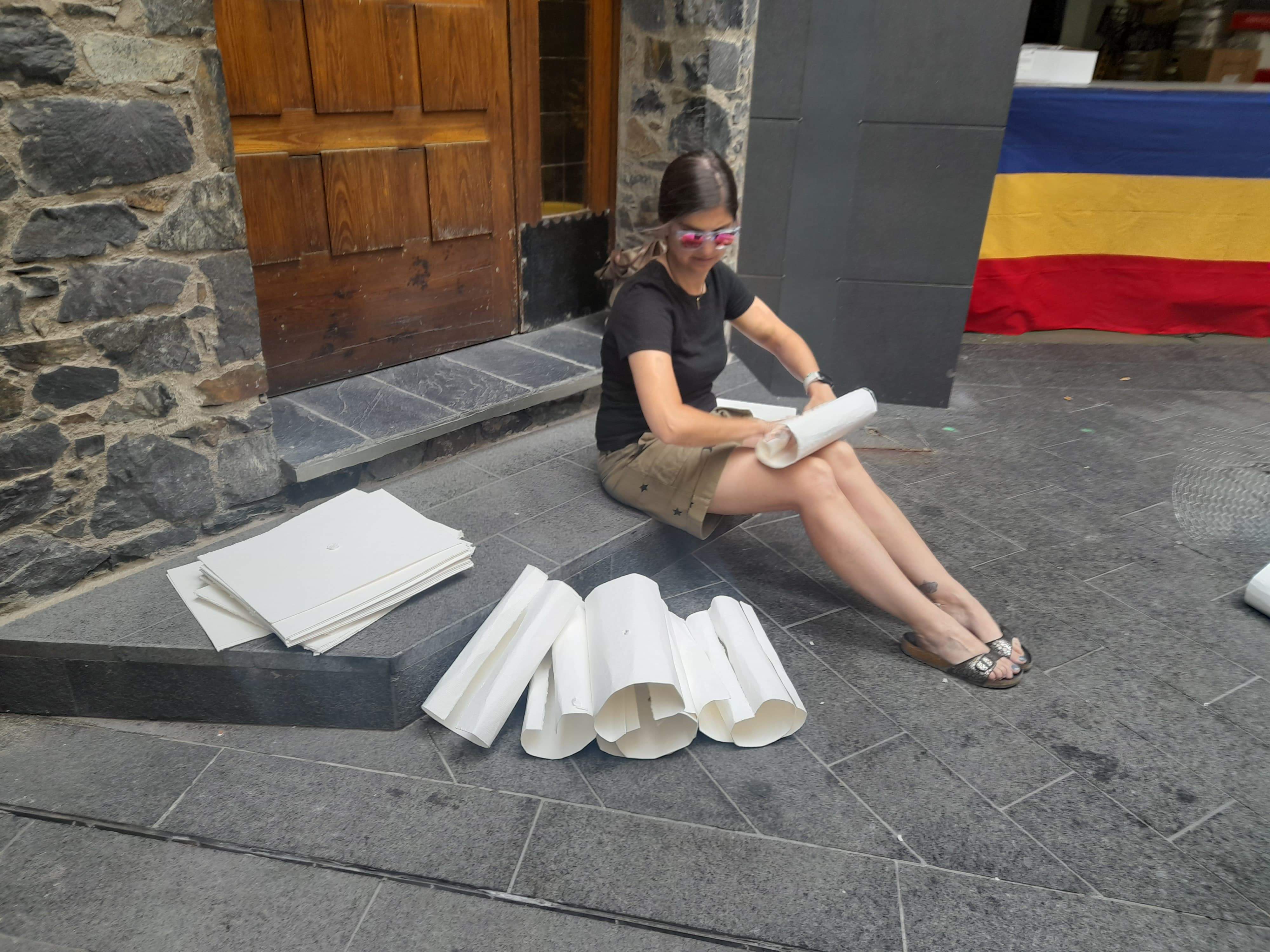 Una de les fallaires enrotllant el paper premsat.