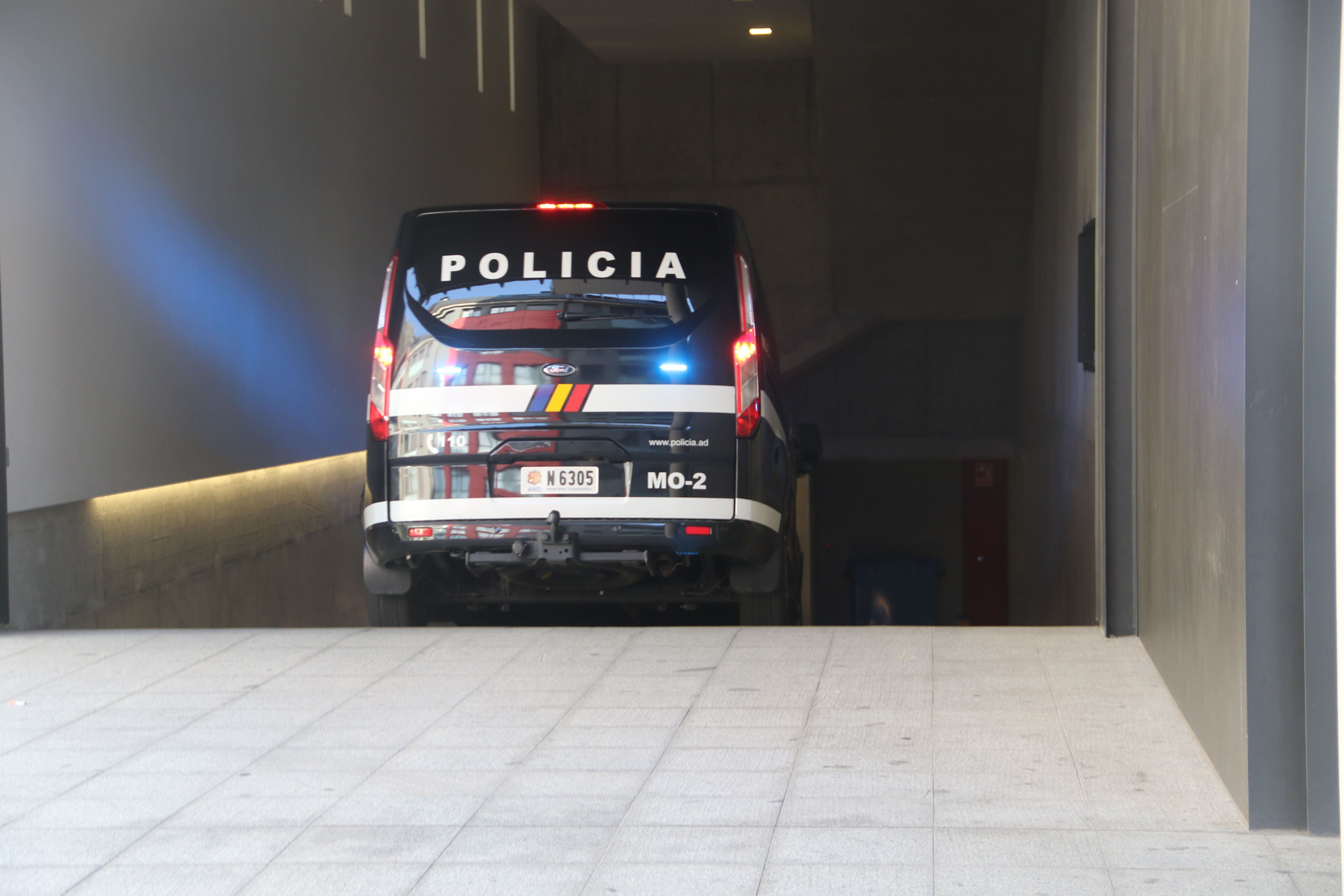 Un cotxe de la policia accedint a la seu de la Justícia amb un detingut.