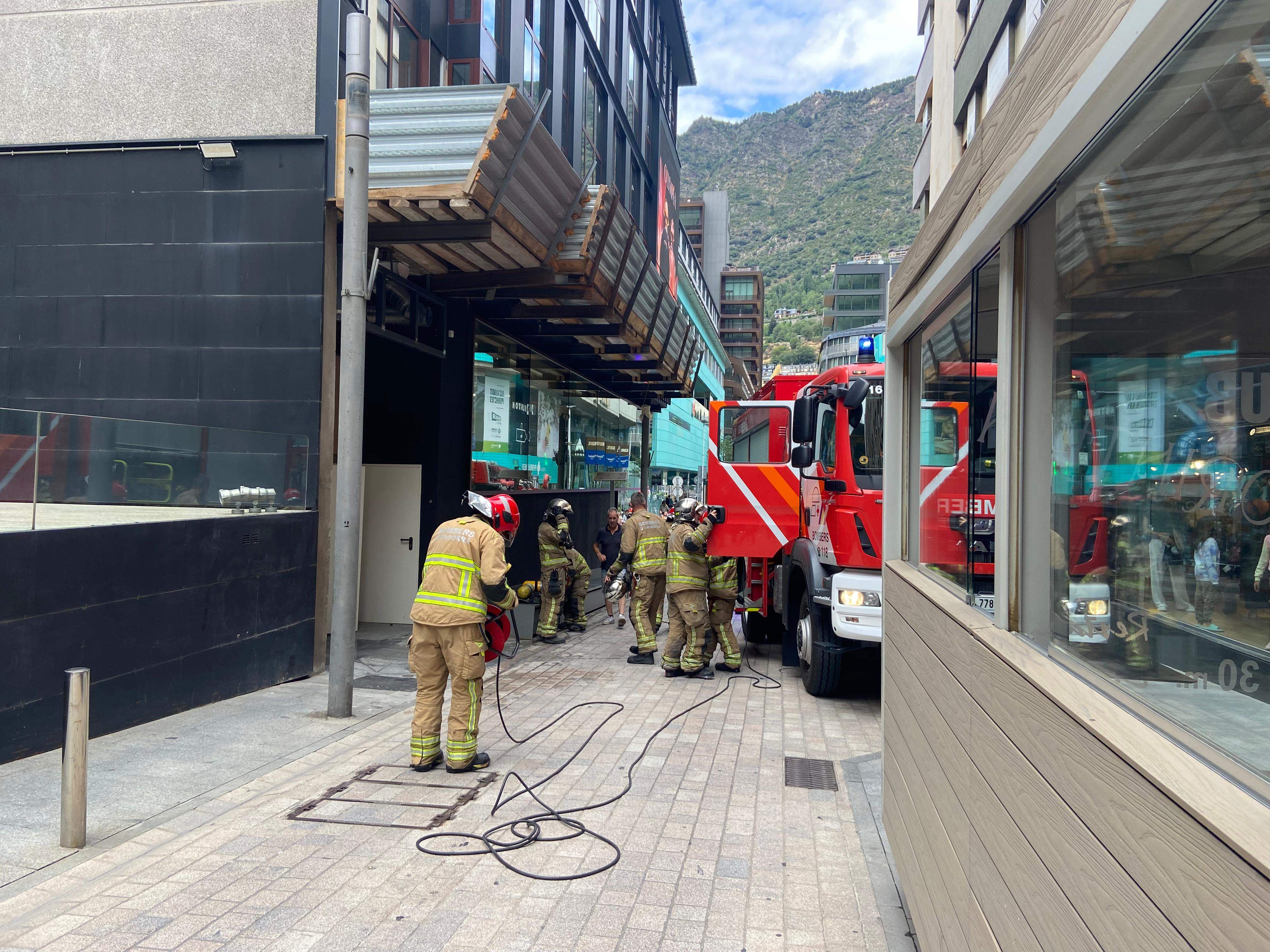 Els bombers recullen el material davant de l'entrada de l'edifici.