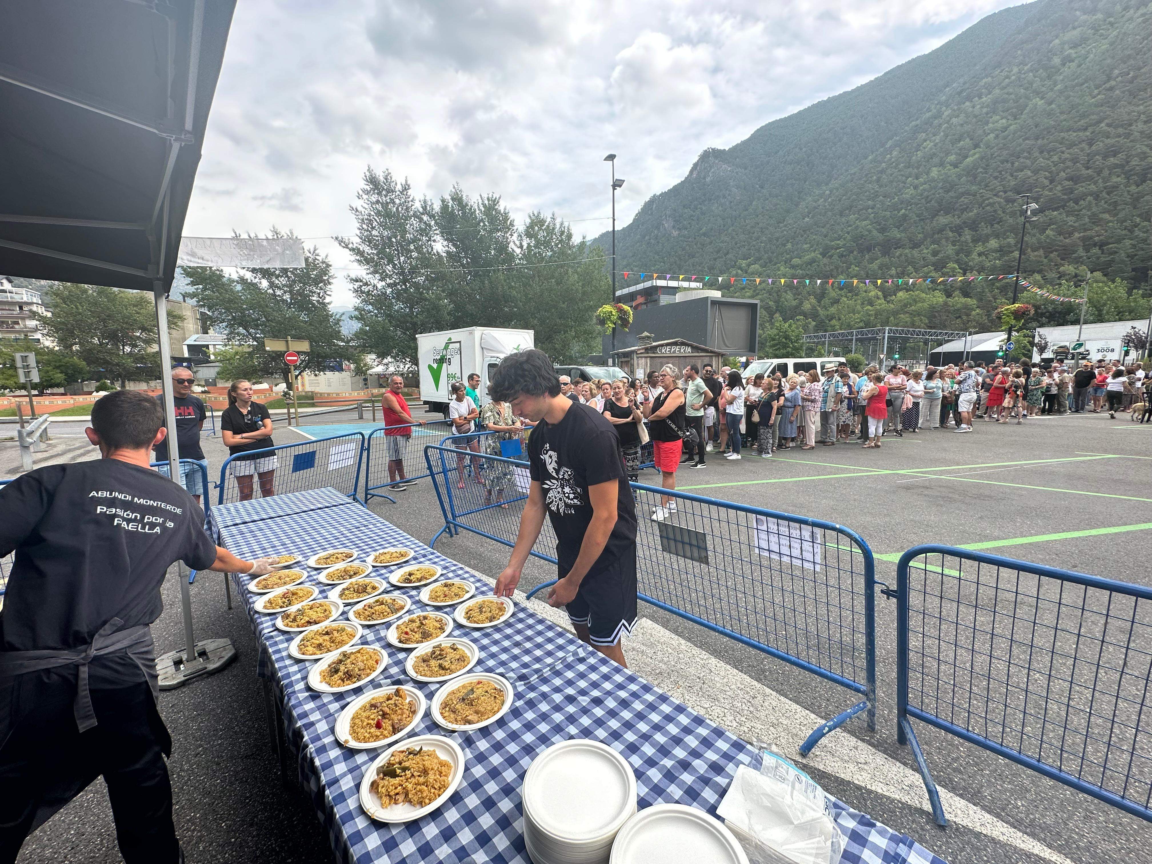 Els assistents fent cua per obtenir el seu plat d'arròs. Els assistents fent cua per obtenir el seu plat d'arròs.
