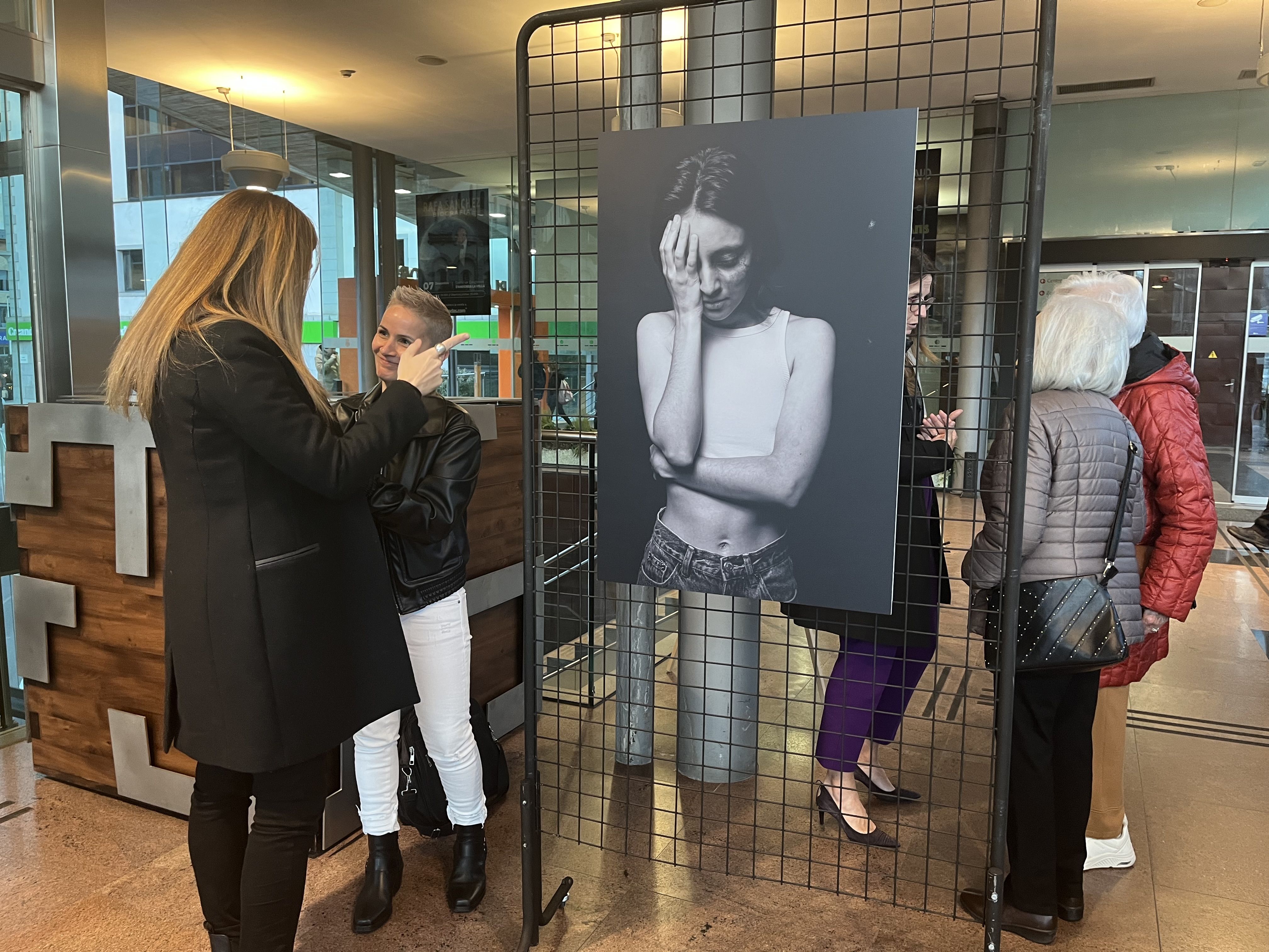 L'artista Chiqui Novis i la ministra de Salut, Helena Mas, mirant una de les imatges.