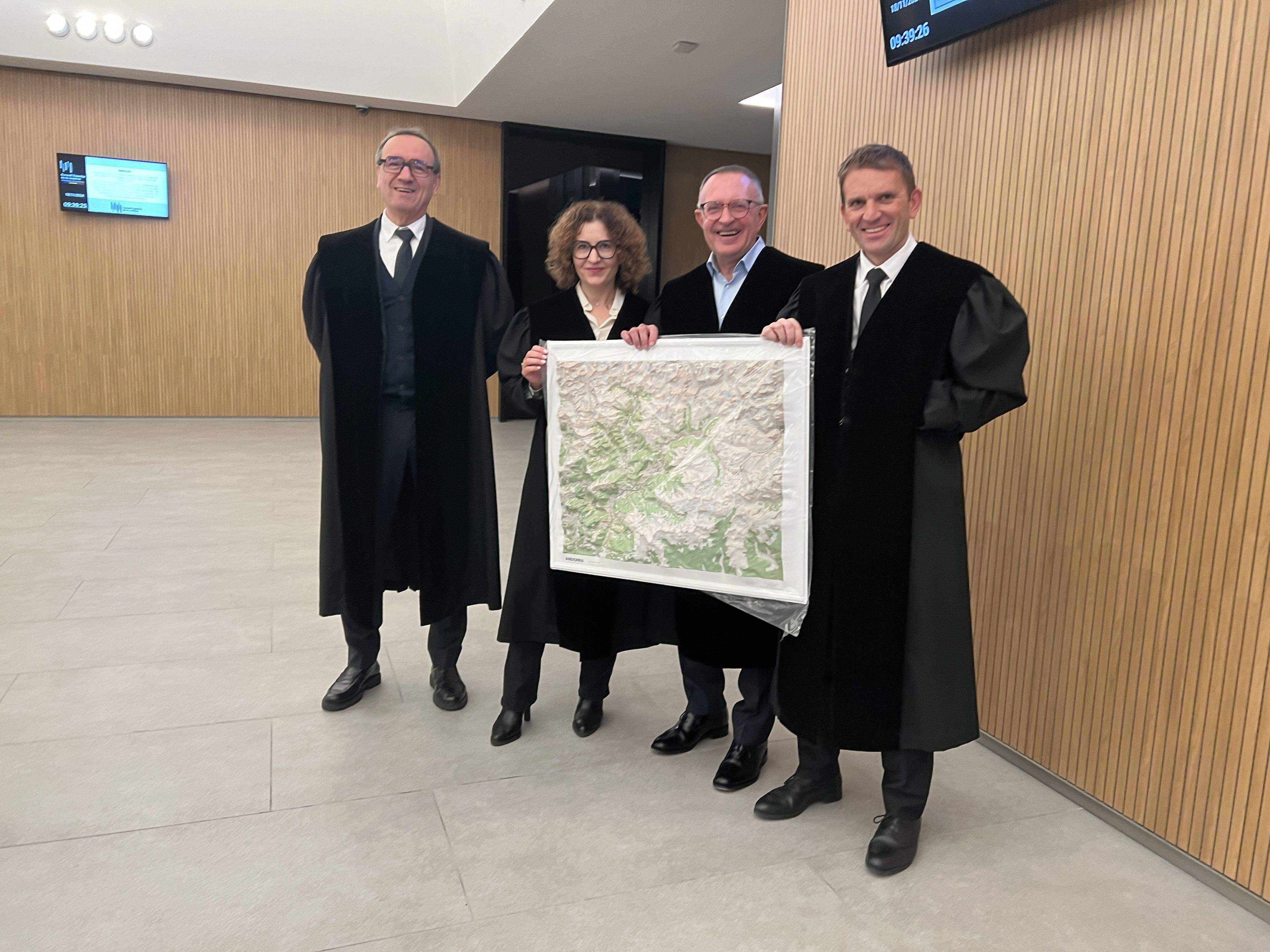 Els quatre advocats que defensen els comuns (Antoni Lalinde, Escaldes; Sònia Ruiz, Andorra la Vella; Xavier Jordana, la Massana; i Enric Giménez, Encamp) amb un mapa en relleu on es veu la zona controvertida.