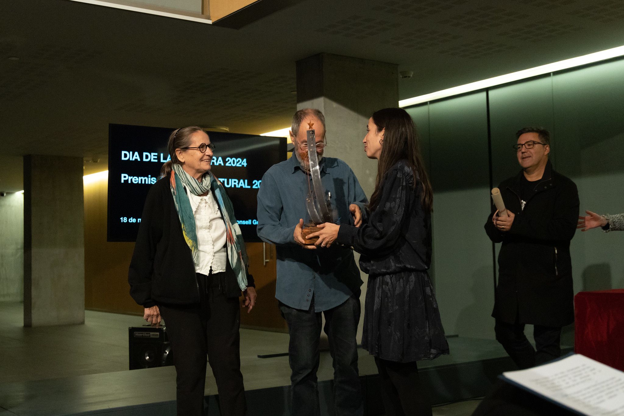 Xavier Rebés, agraïnt el premi juntament amb Fina Font, que entrega la cònsol menor Olalla Losada. Xavier Rebés, agraïnt el premi juntament amb Fina Font, que entrega la cònsol menor Olalla Losada.