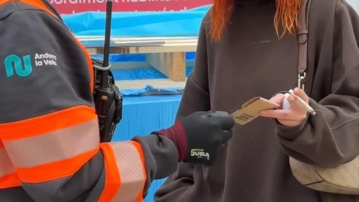 Operaris del comú, mostrant un dels cendrers portàtils a una ciutadana. 