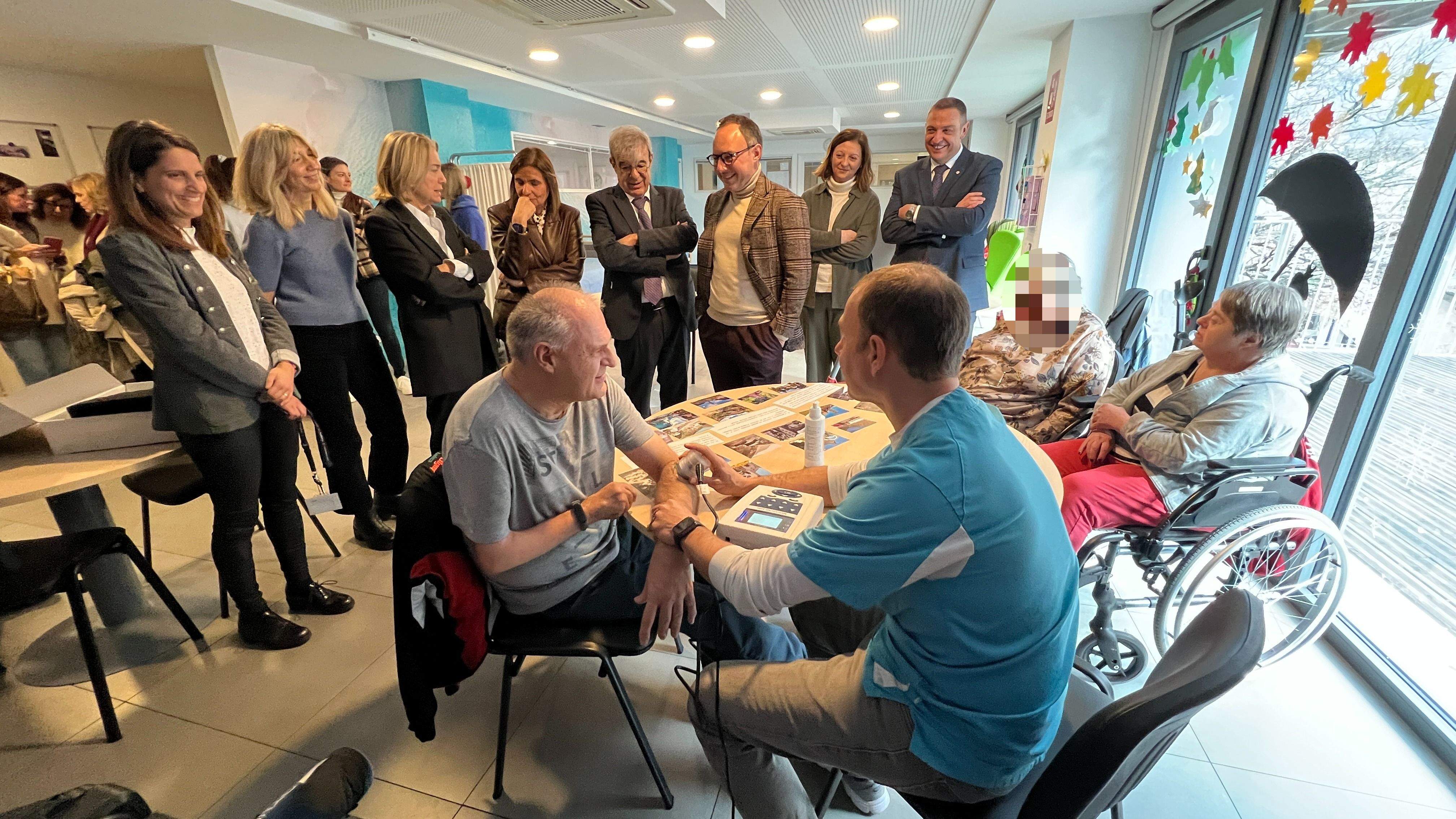 Les autoritats polítiques i de la fundació observant el funcionament de l'aparell d'ultrasò en un usuari.