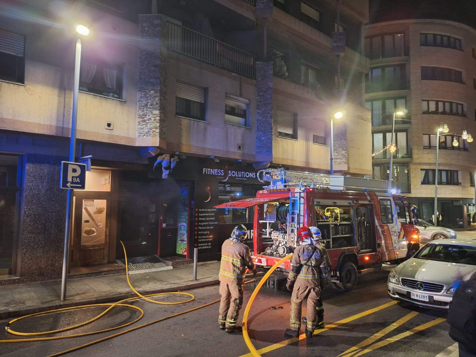 Els bombers intentant apagant el foc al local situat al carrer Pere d'Urg.