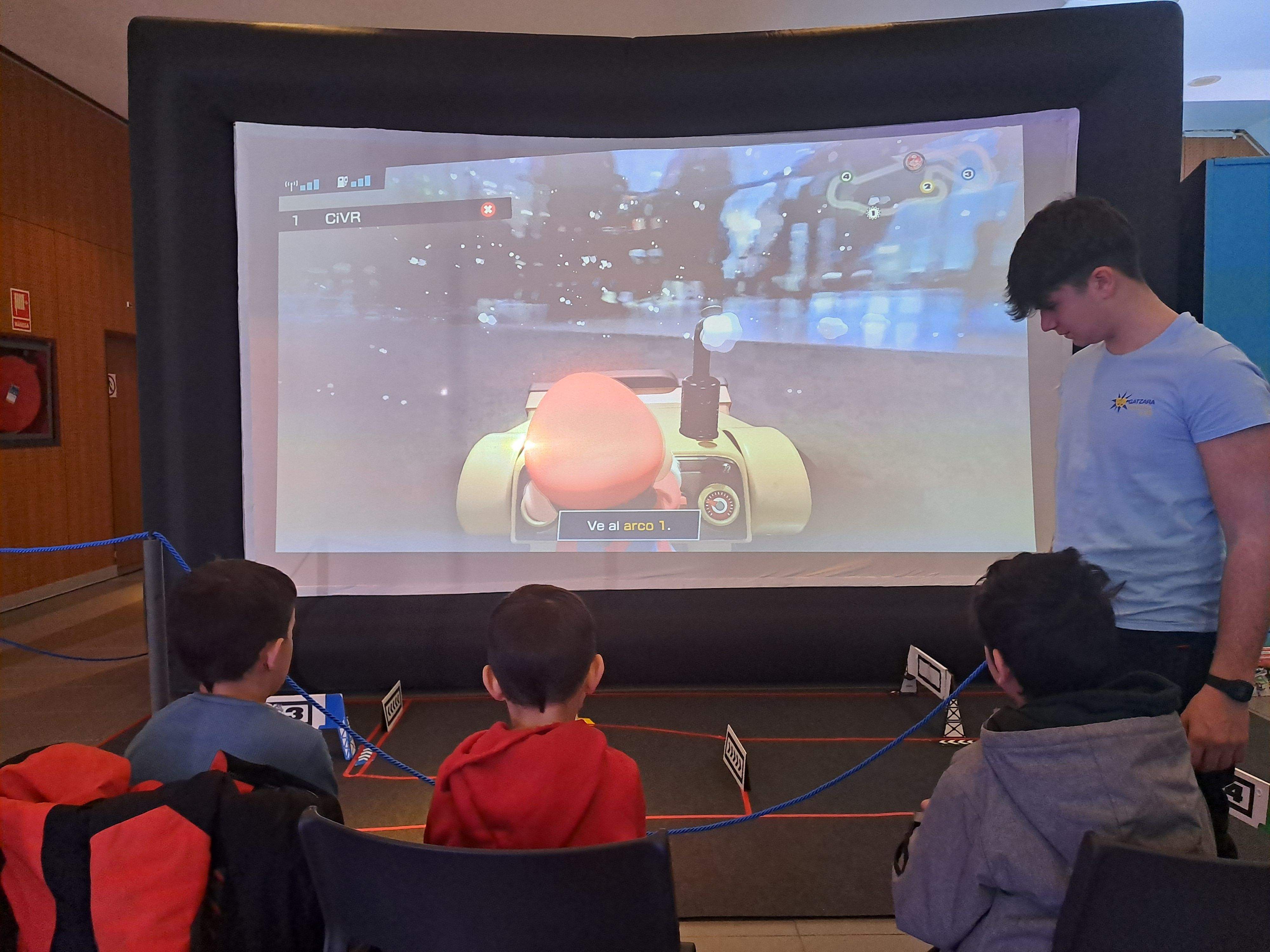 Infants jugant a un joc electrònic de carreres.