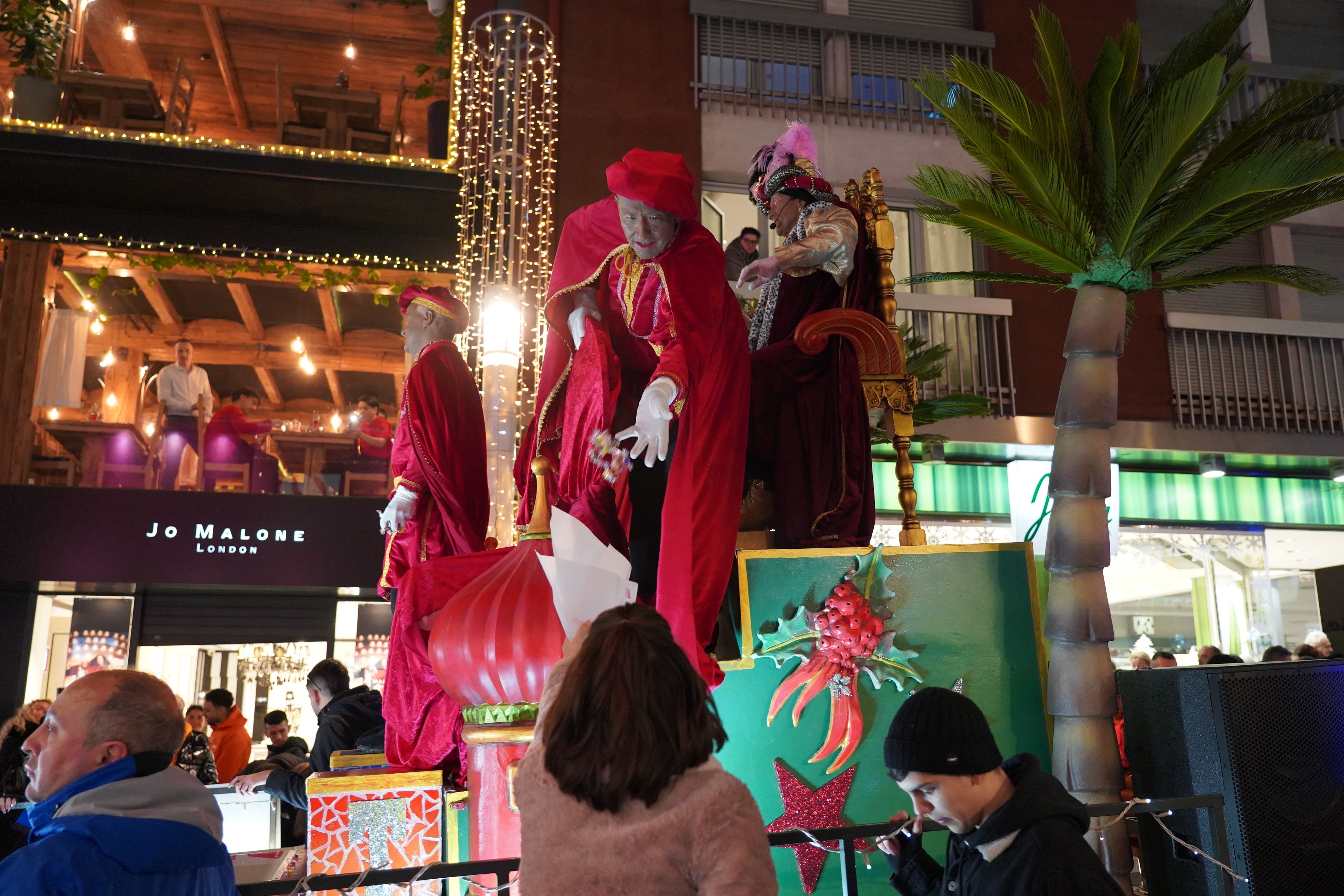 Una nena rep caramels durant la cavalcada.