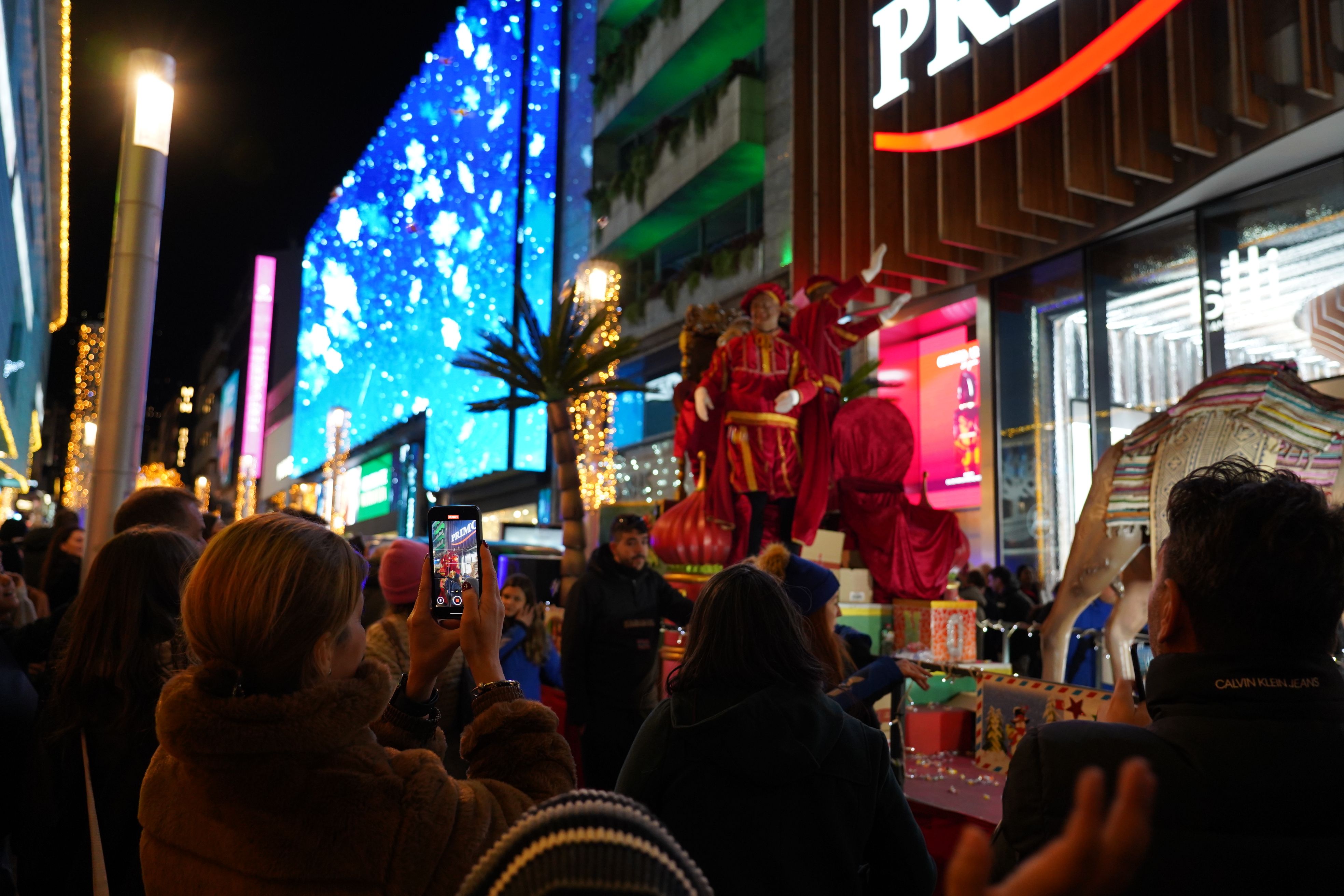 Una dona fotografia el Patge durant la cavalcada.