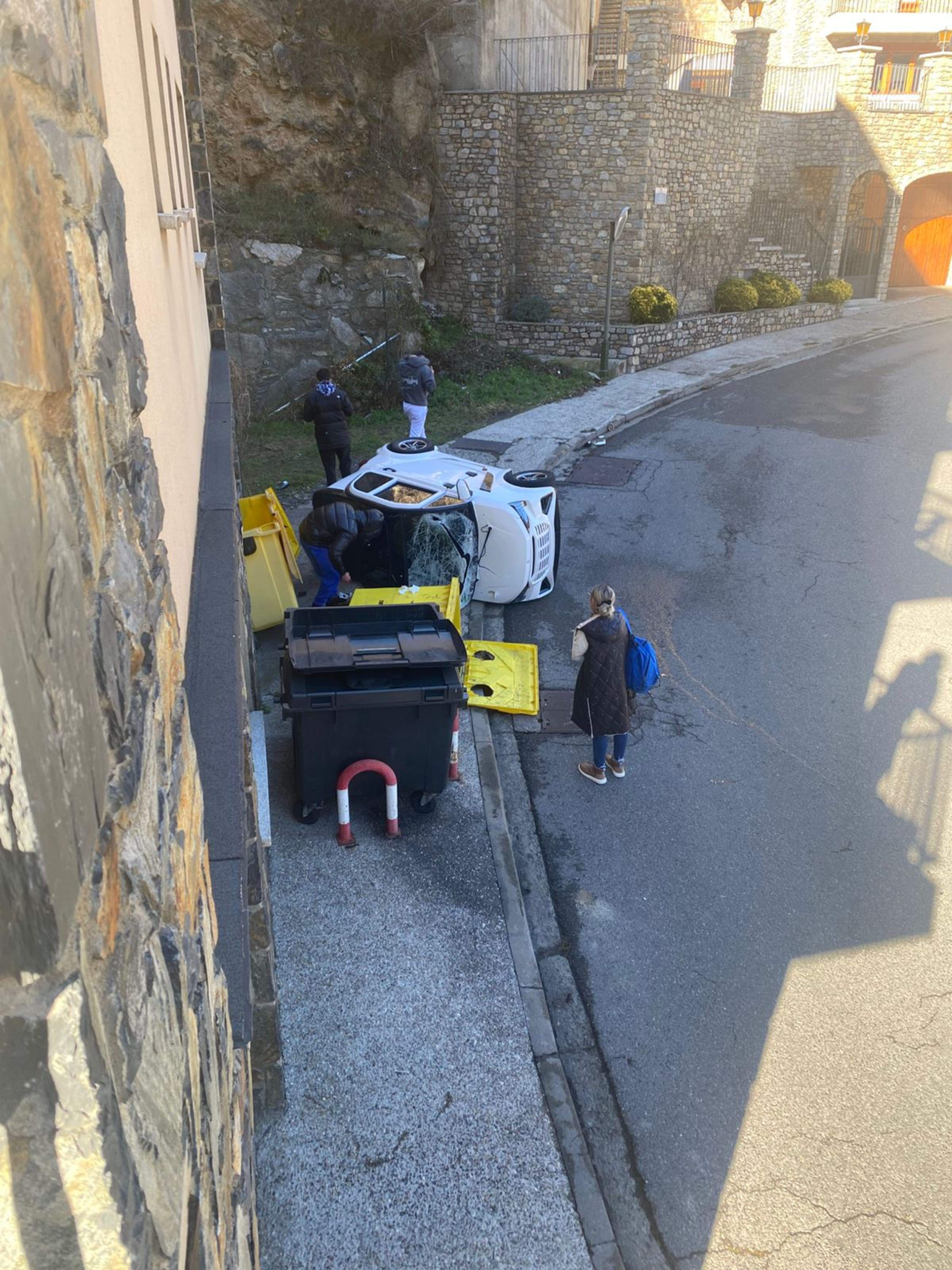 El vehicle accidentat, observat per diverses persones.