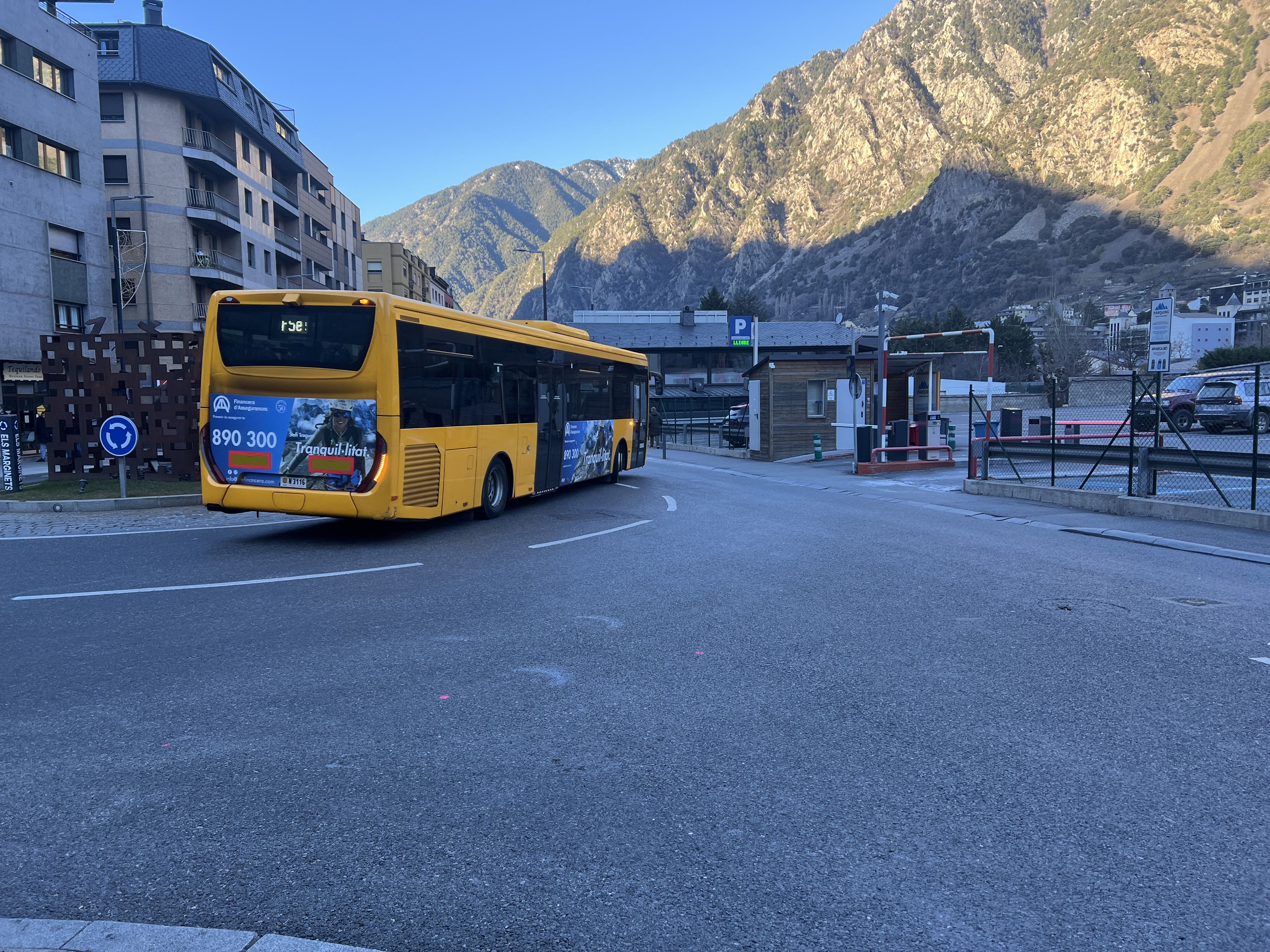 Un autobús fent la rotonda just en passar davant de l'accés a l'aparcament.
