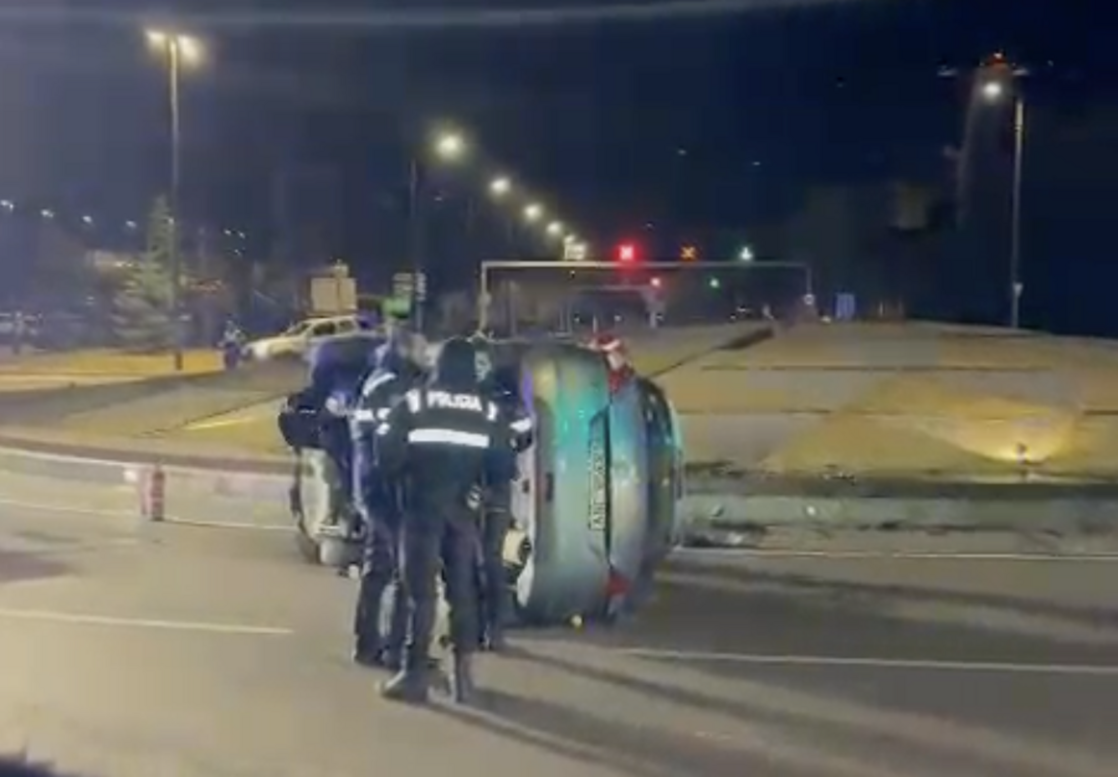 El cotxe bolcat a la rotonda de la Comella amb agents de policia fent el corresponent atestat.