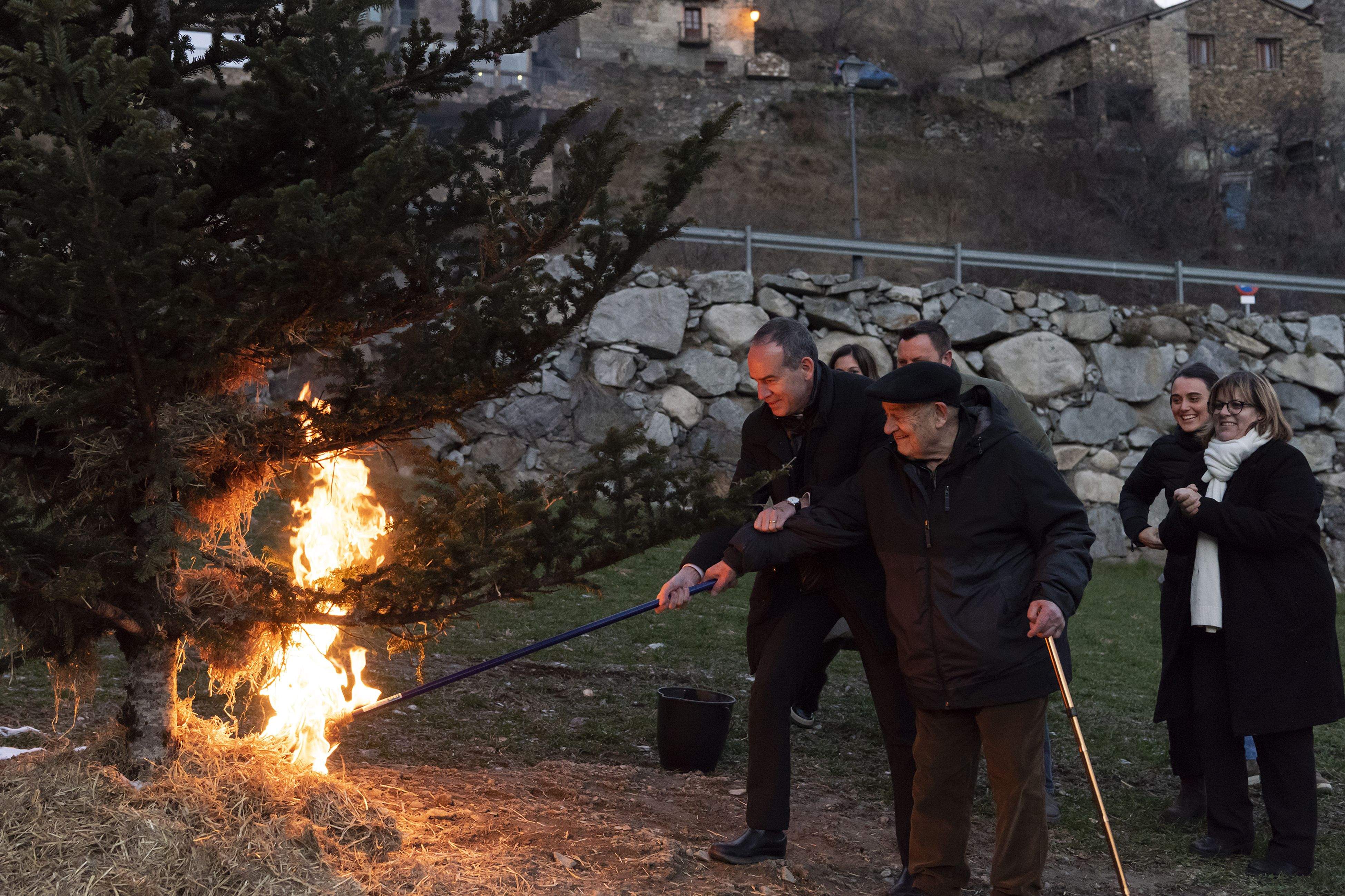 El cònsol de Canillo i mossèn Ramon, encenent l'arbre en qüestió.