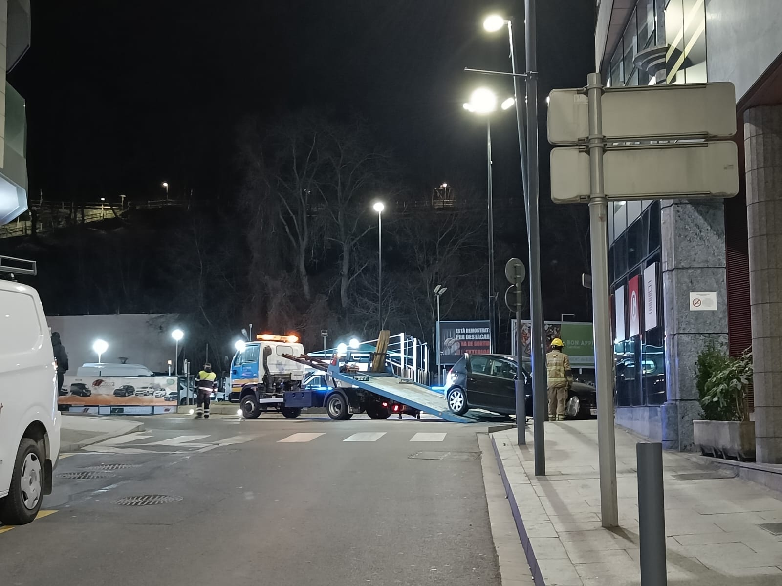 Una grua amb plataforma carrega el cotxe accidentat. Una grua amb plataforma carrega el cotxe accidentat.