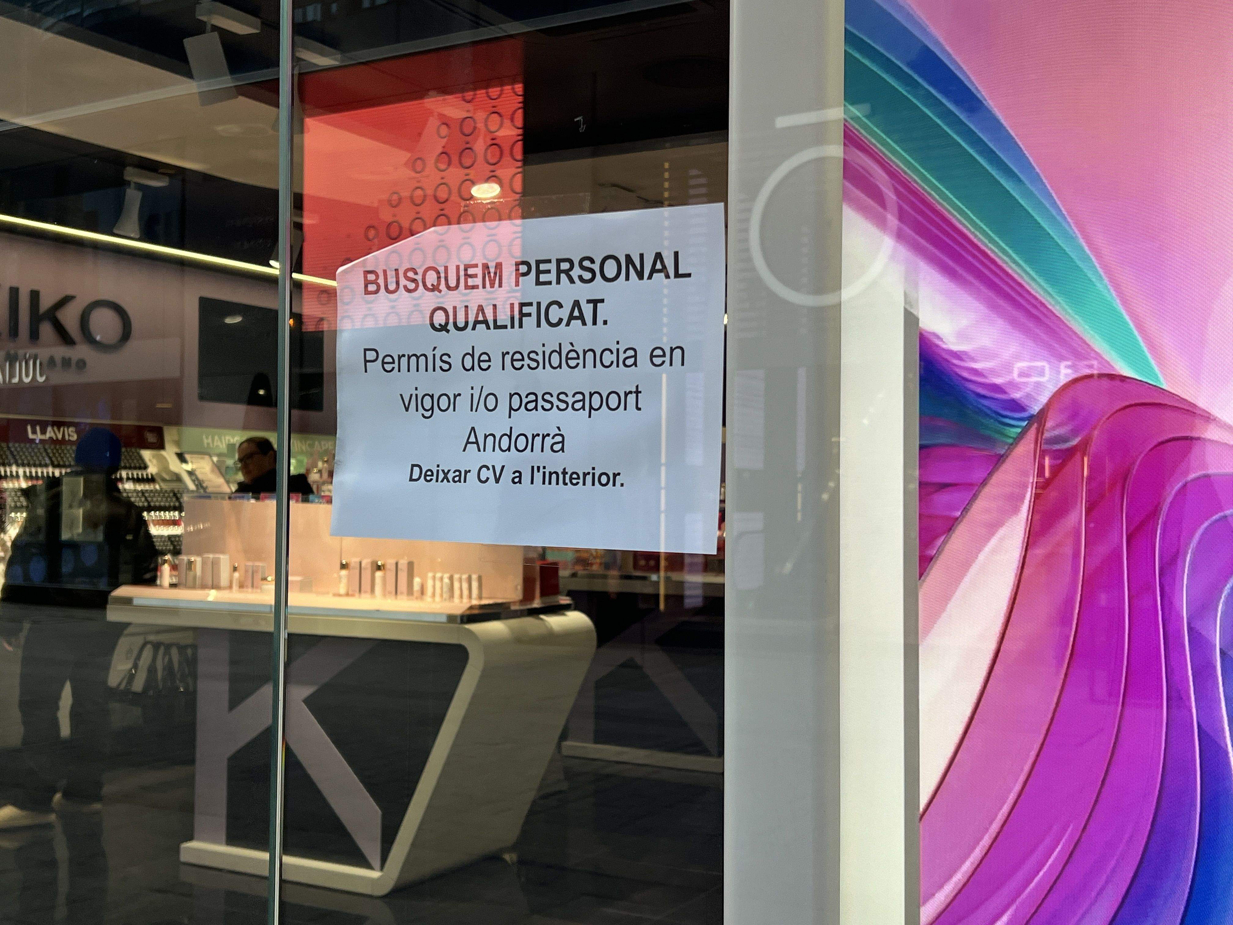 Un rètol en l'aparador d'un comerç del país cercant personal.