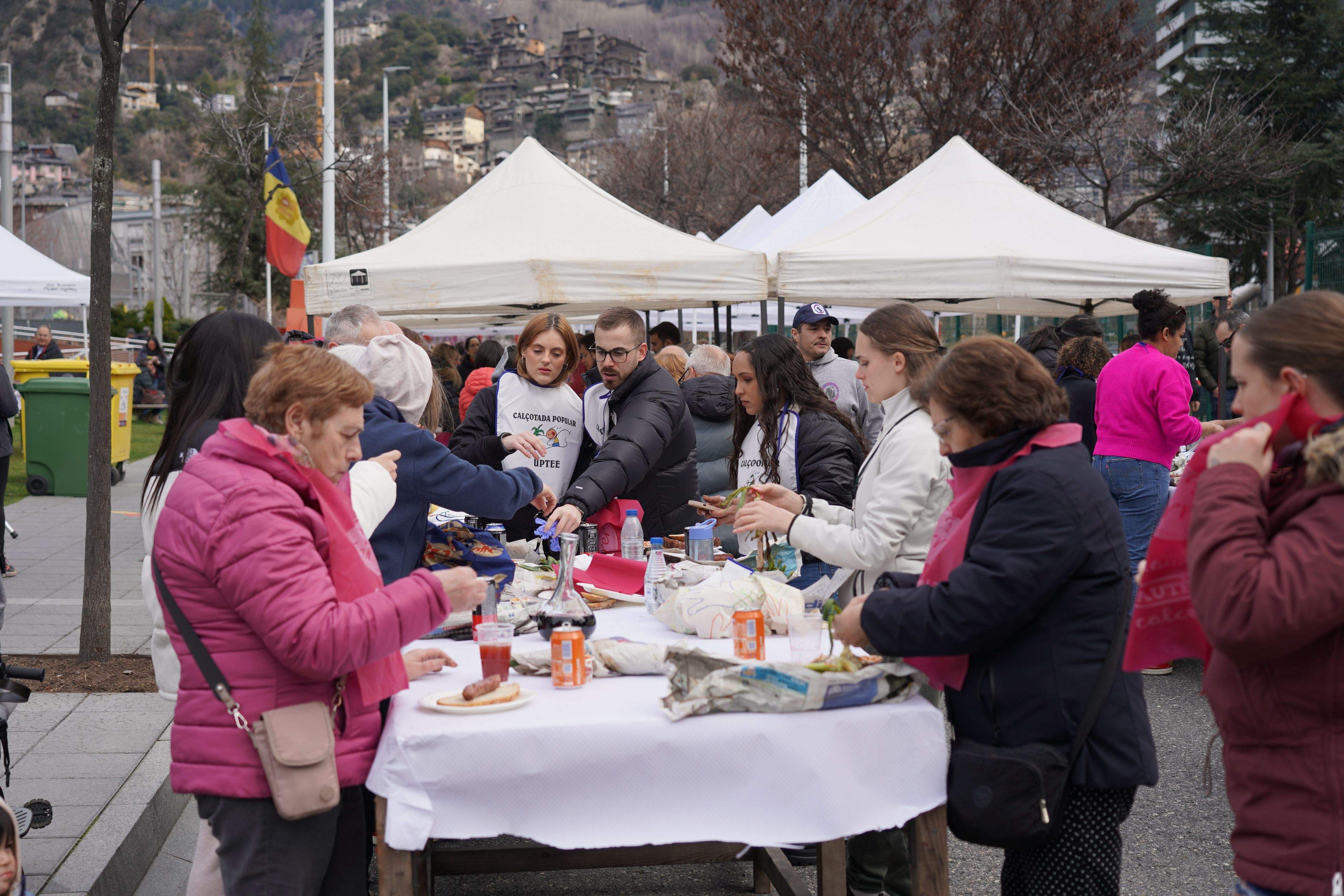 Les taules plenes de gent menjant calçots.