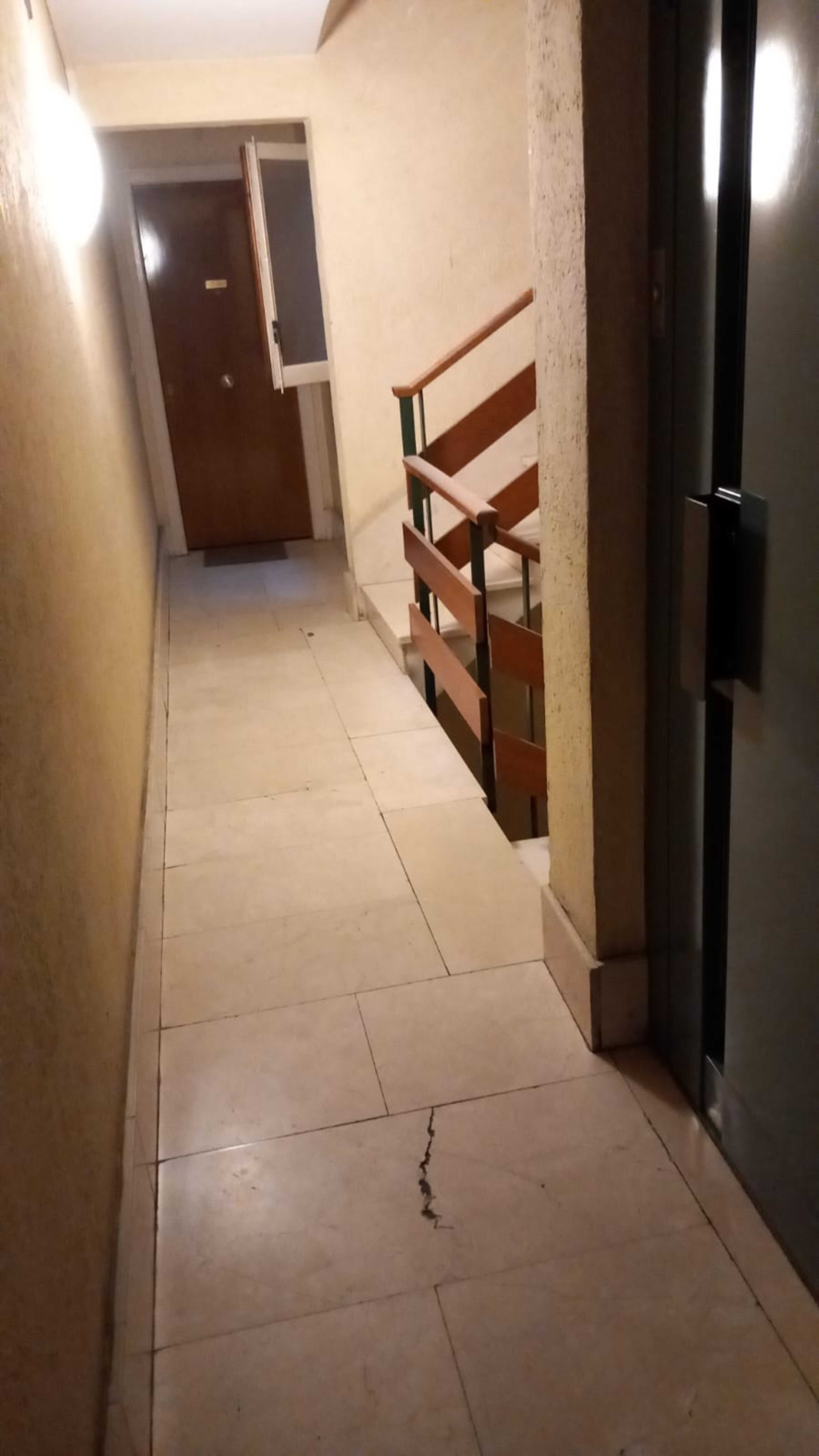 Una finestra oberta i la barana de l'escala encara plena de pols en un dels replans de l'edifici afectat.