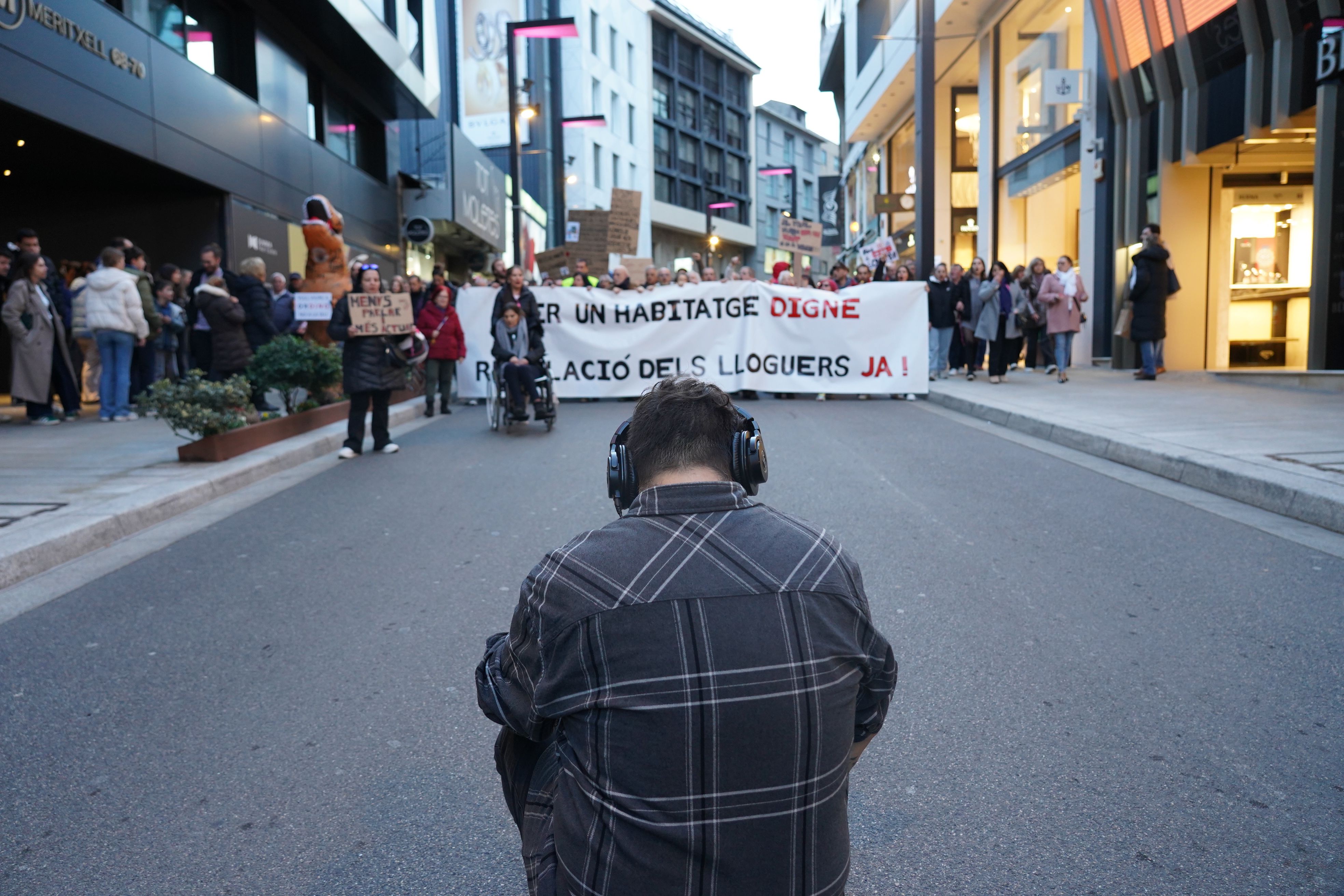 Un càmara agafa imatges de la capçalera de la manifestació al seu pas per l'avinguda Meritxell.